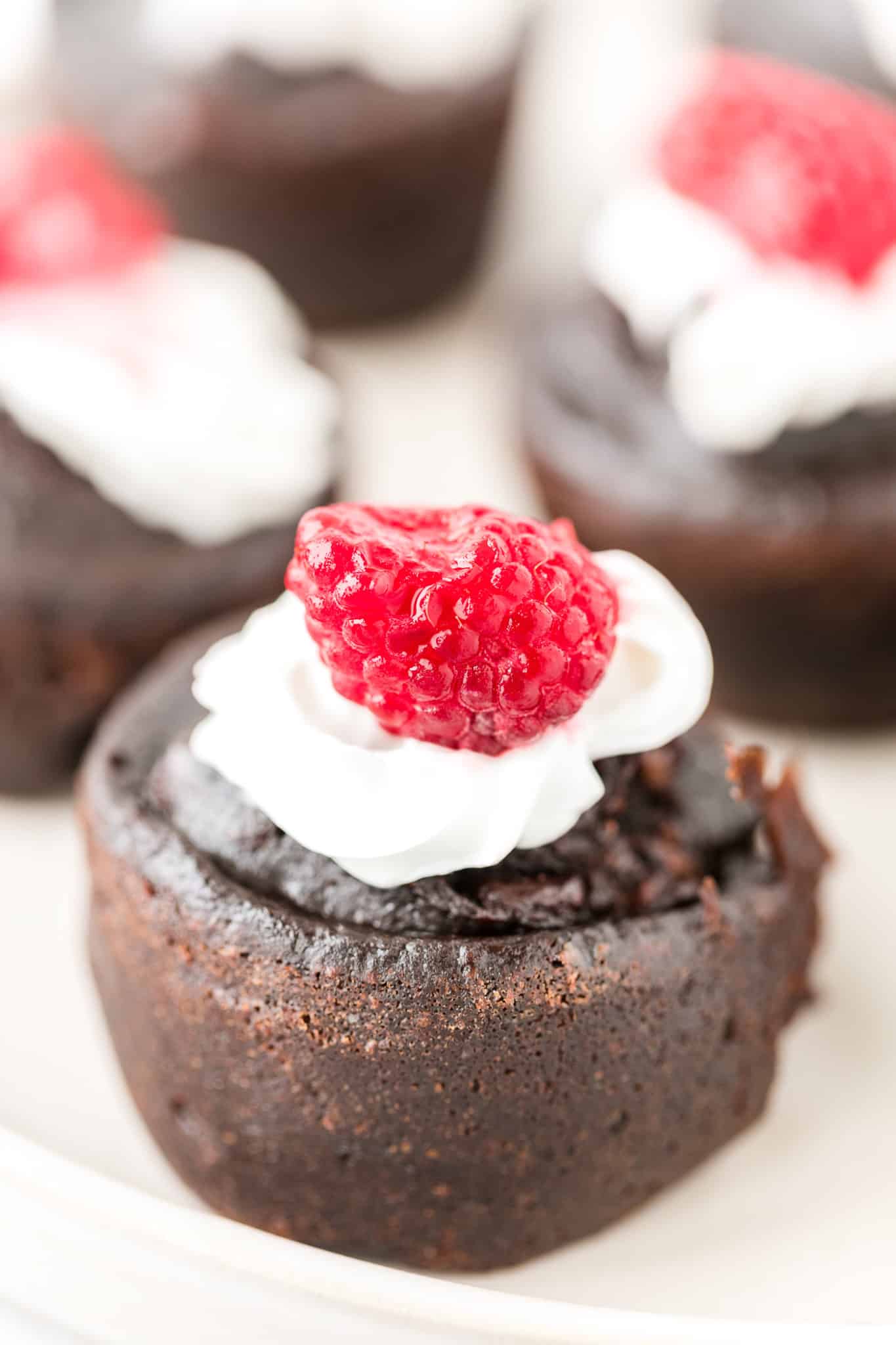 instant pot brownie bite on a plate topped with coconut whipped cream and a raspberry