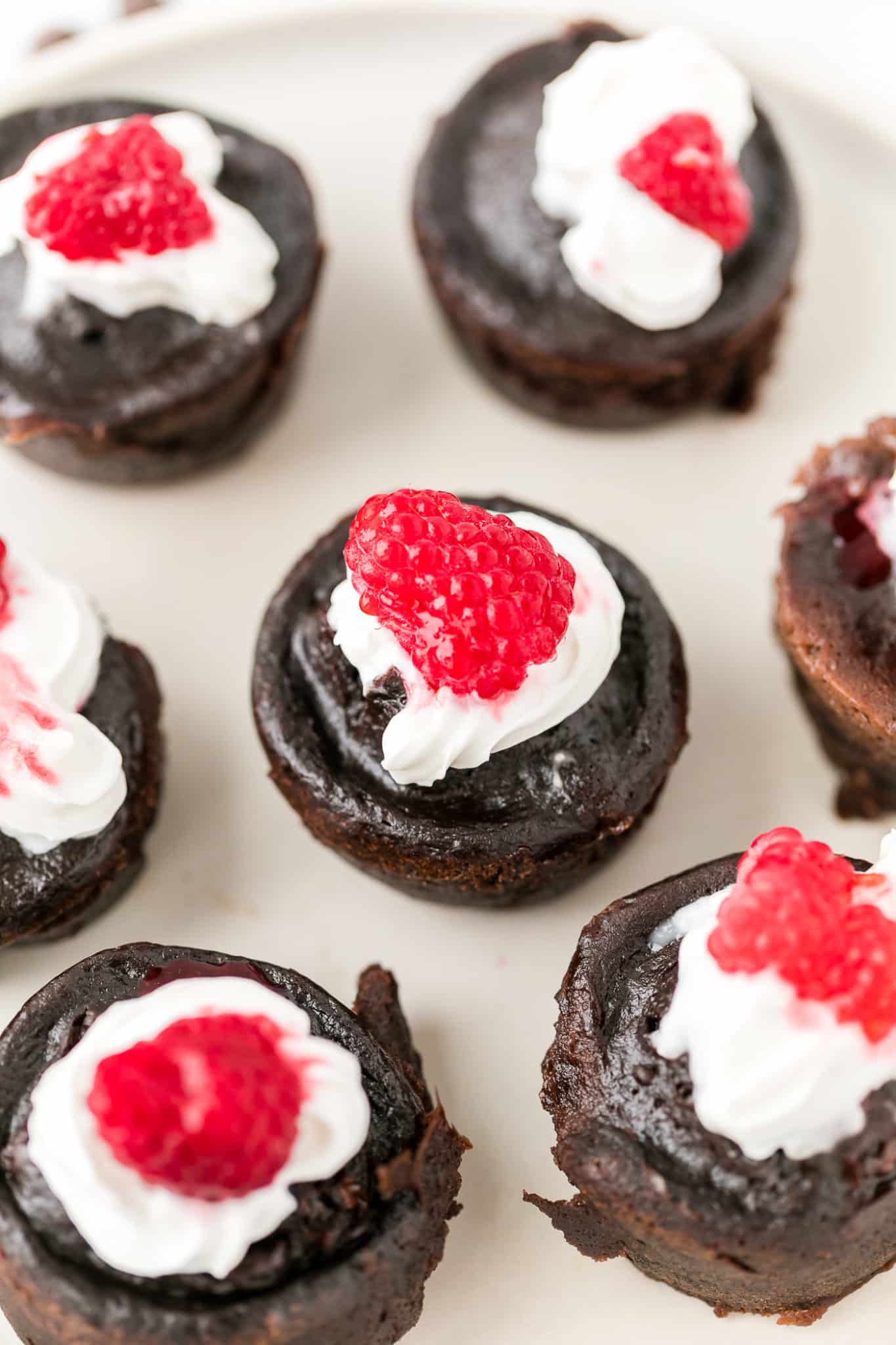 plate of instant pot brownie bites served with whipped cream and raspberries on top