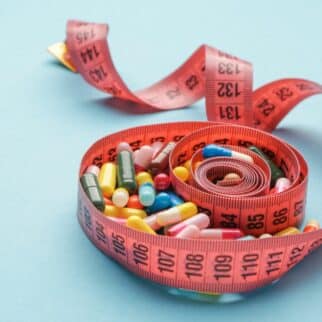 pink measuring tape filled with pills.