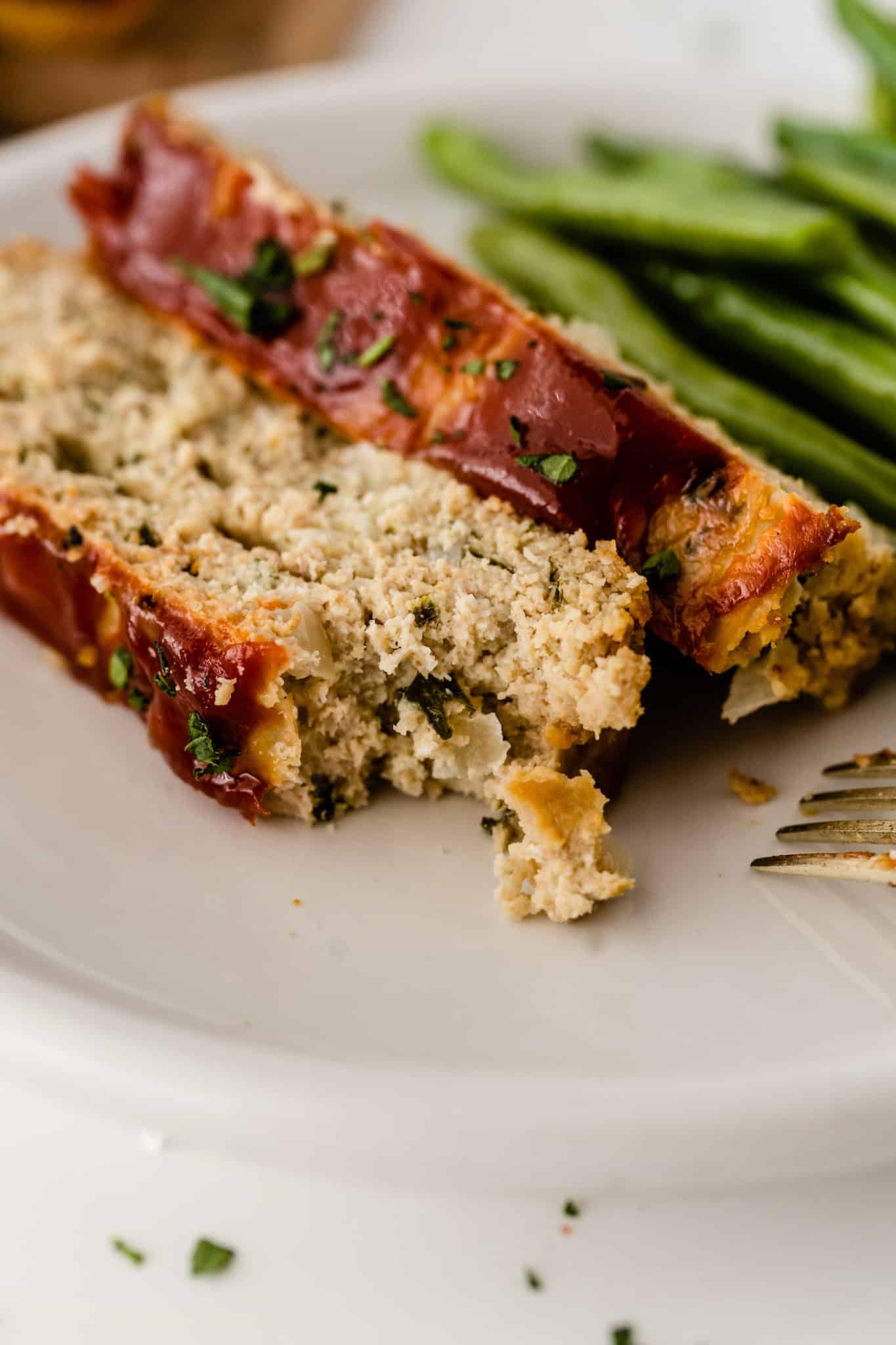 up close picture of cooked chicken meatloaf on a plate.