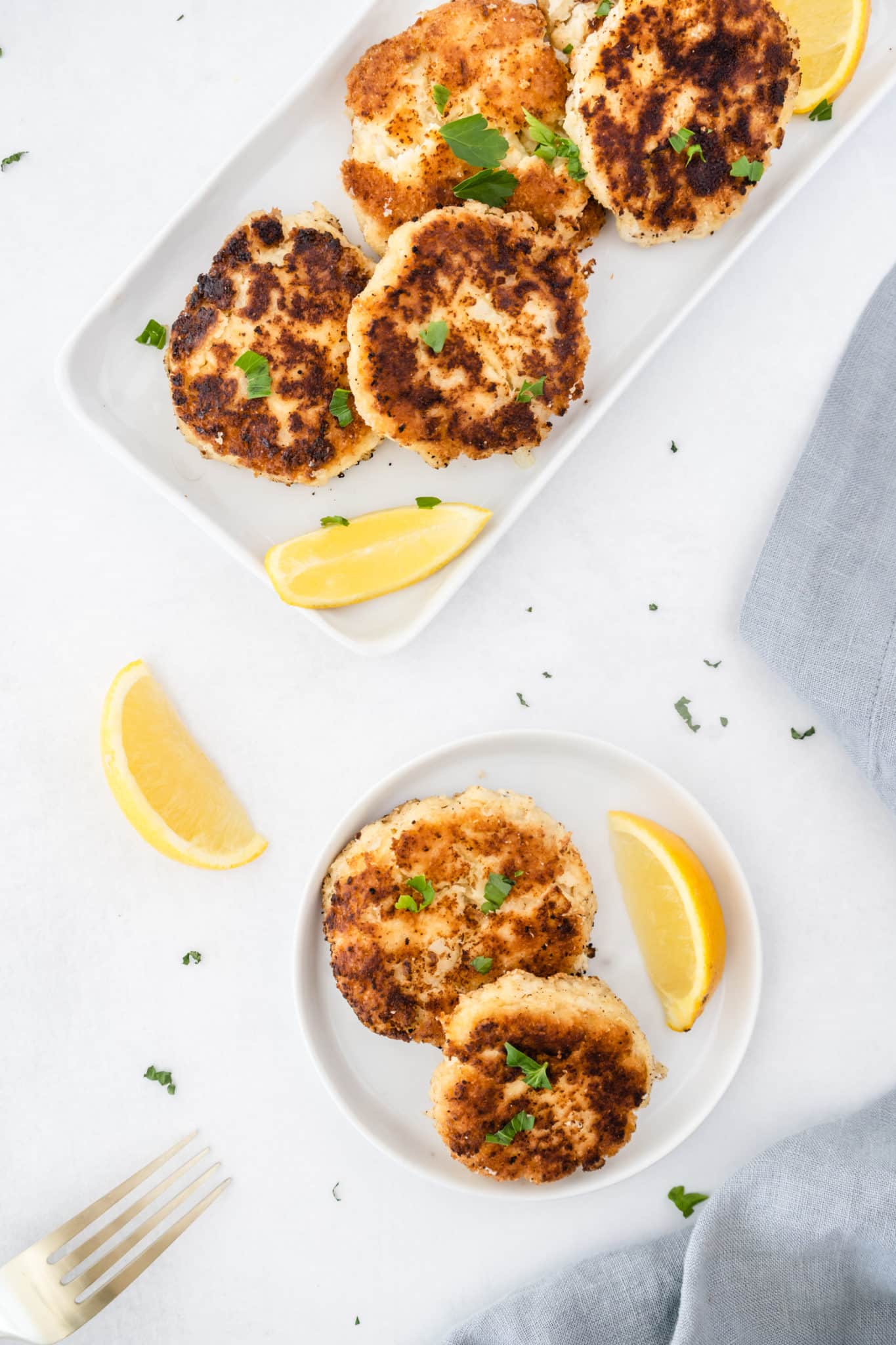 gluten-free crab cakes served with fresh parsley and lemon slices.