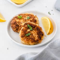 crab cakes served on a white plate with fresh lemon