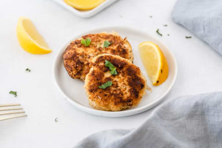 crab cakes served on a white plate with fresh lemon