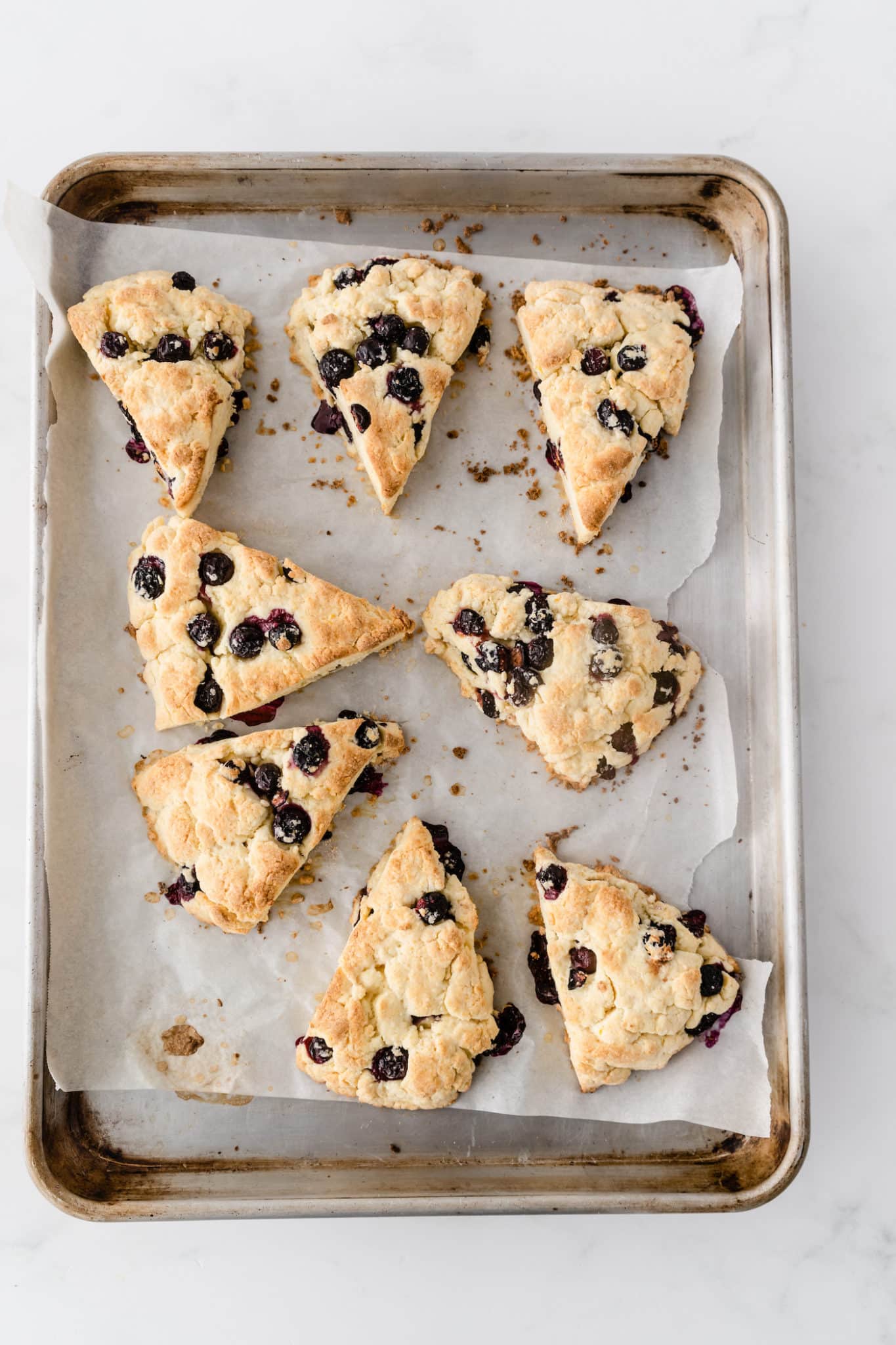 baked gluten-free blueberry scones on a baking sheet.