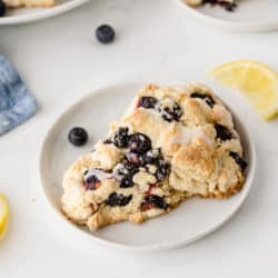blueberry scone on a plate with fresh lemon slices