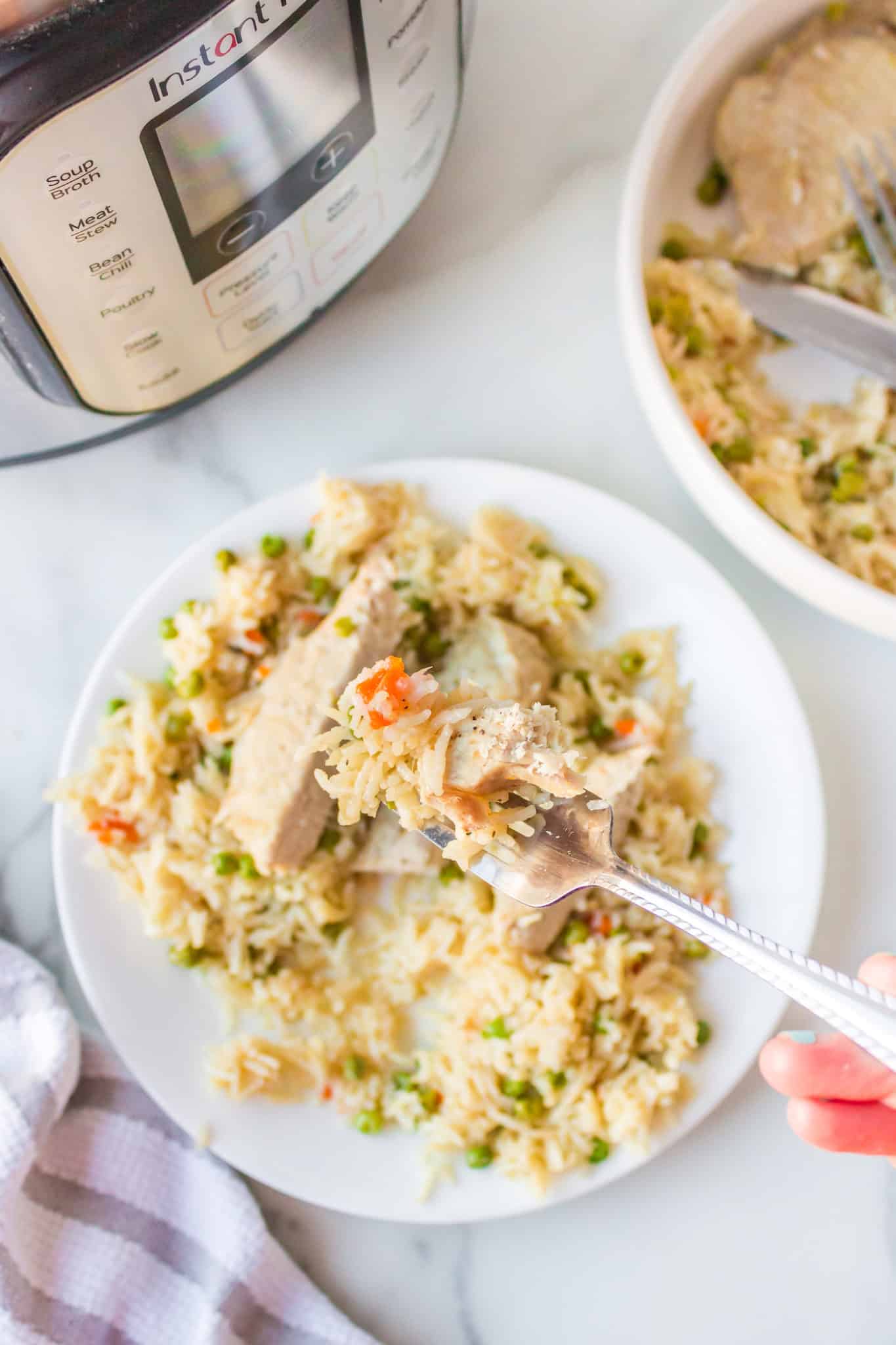 fork with a bite of instant pot pork chops and rice.