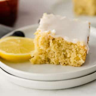 slice of lemon cake on a plate with fresh lemon