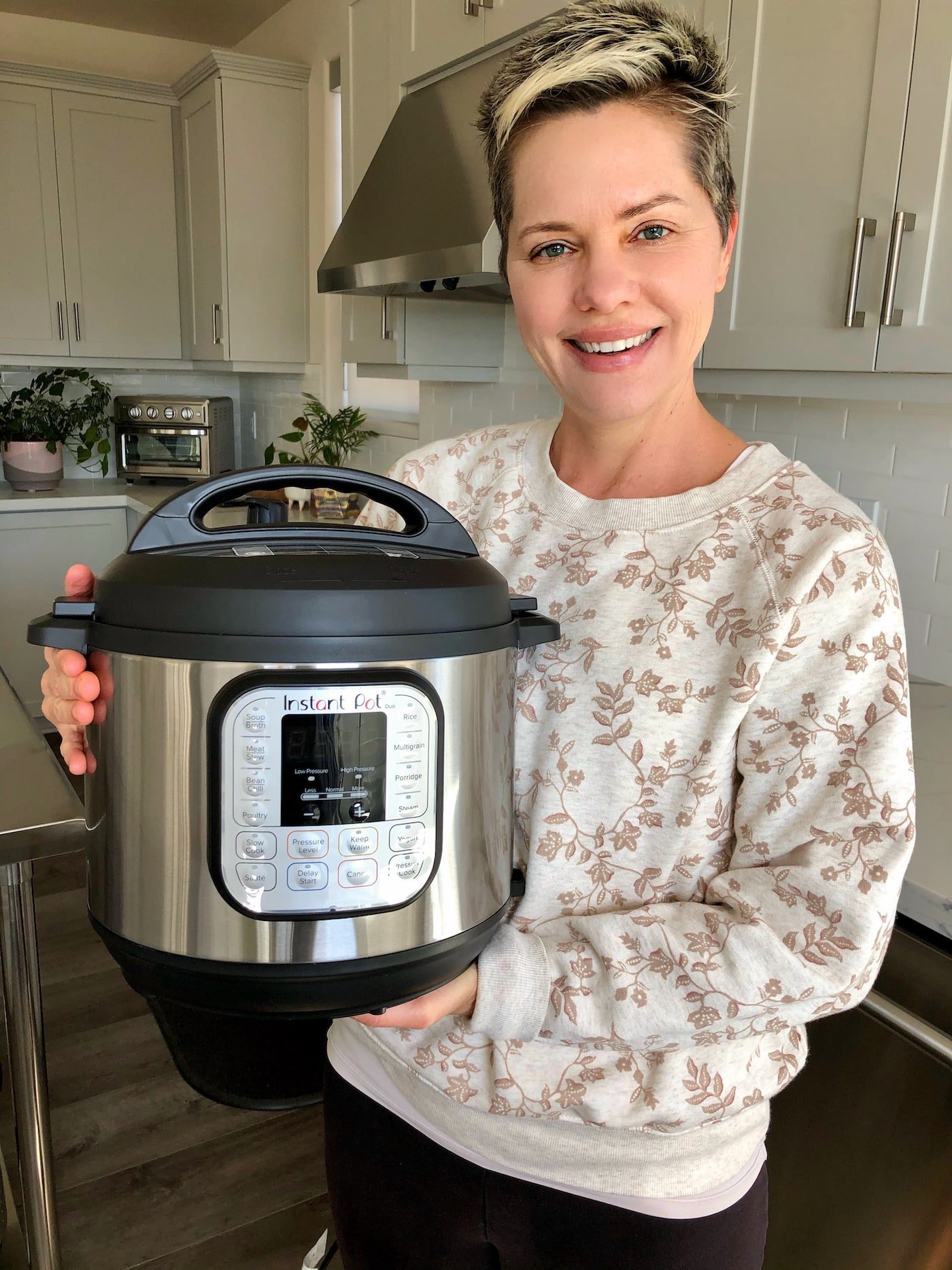 carrie holding an instant pot duo pressure cooker.