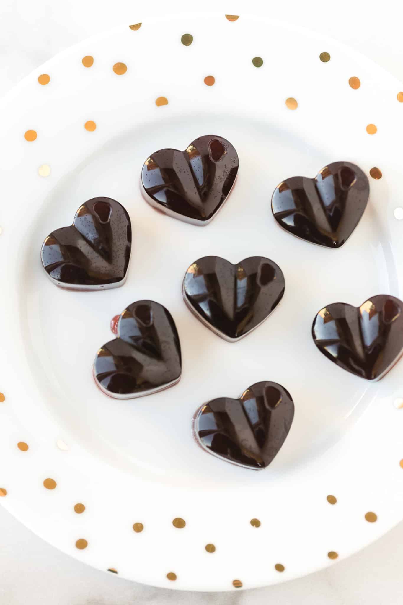 heart shaped homemade cbd gummies on a white plate.