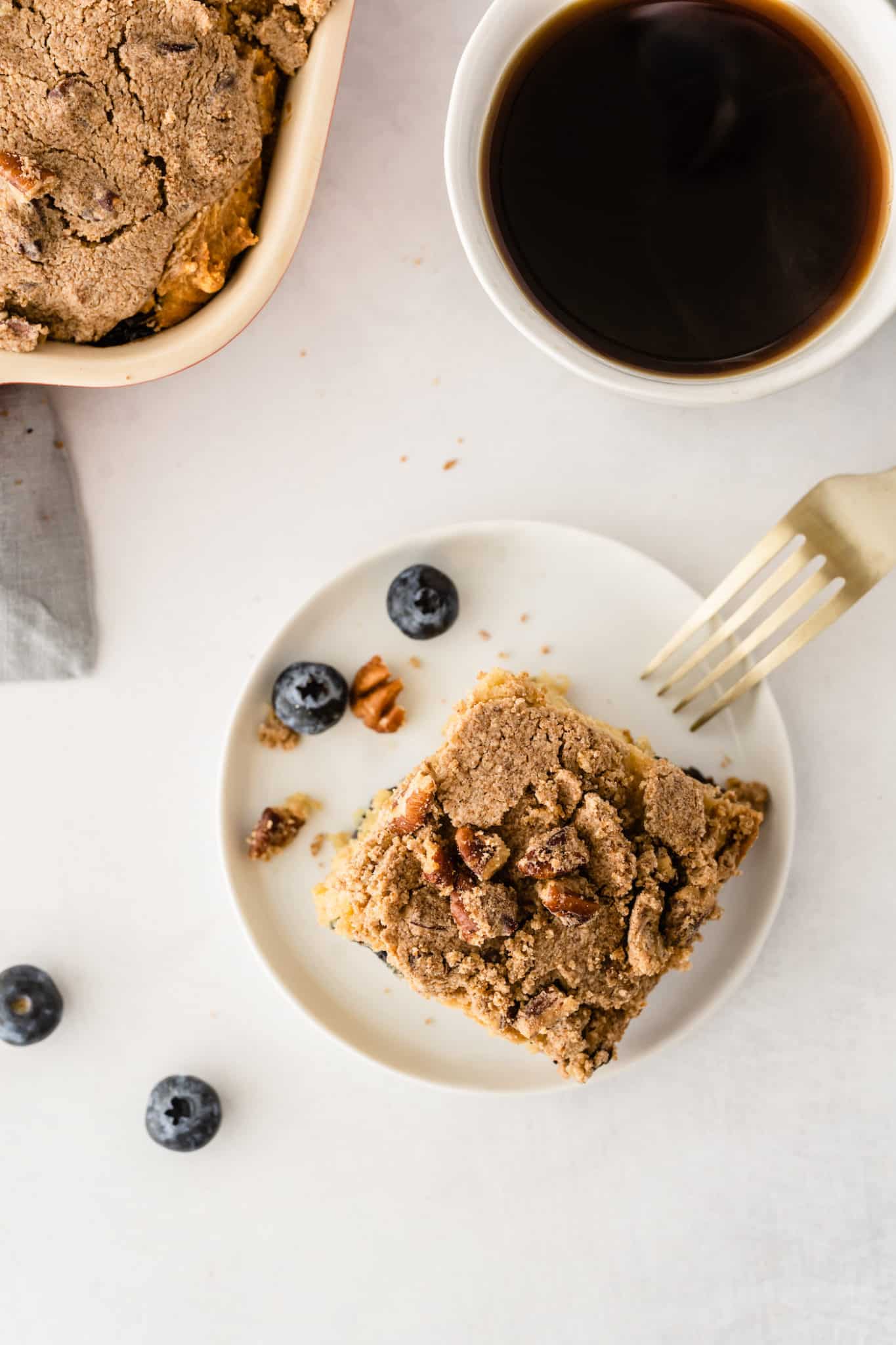 overhead shot of coffee cake served with a mug of hot coffee.