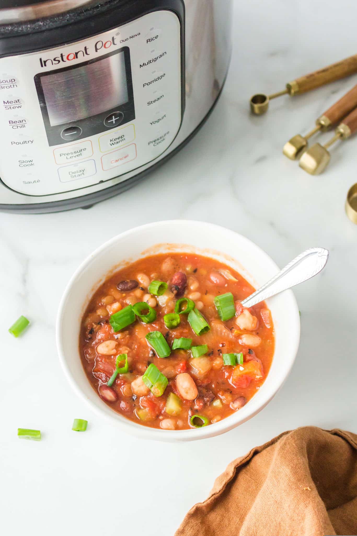 white bowl filled with cooked instant pot 15 bean soup ready to be enjoyed.