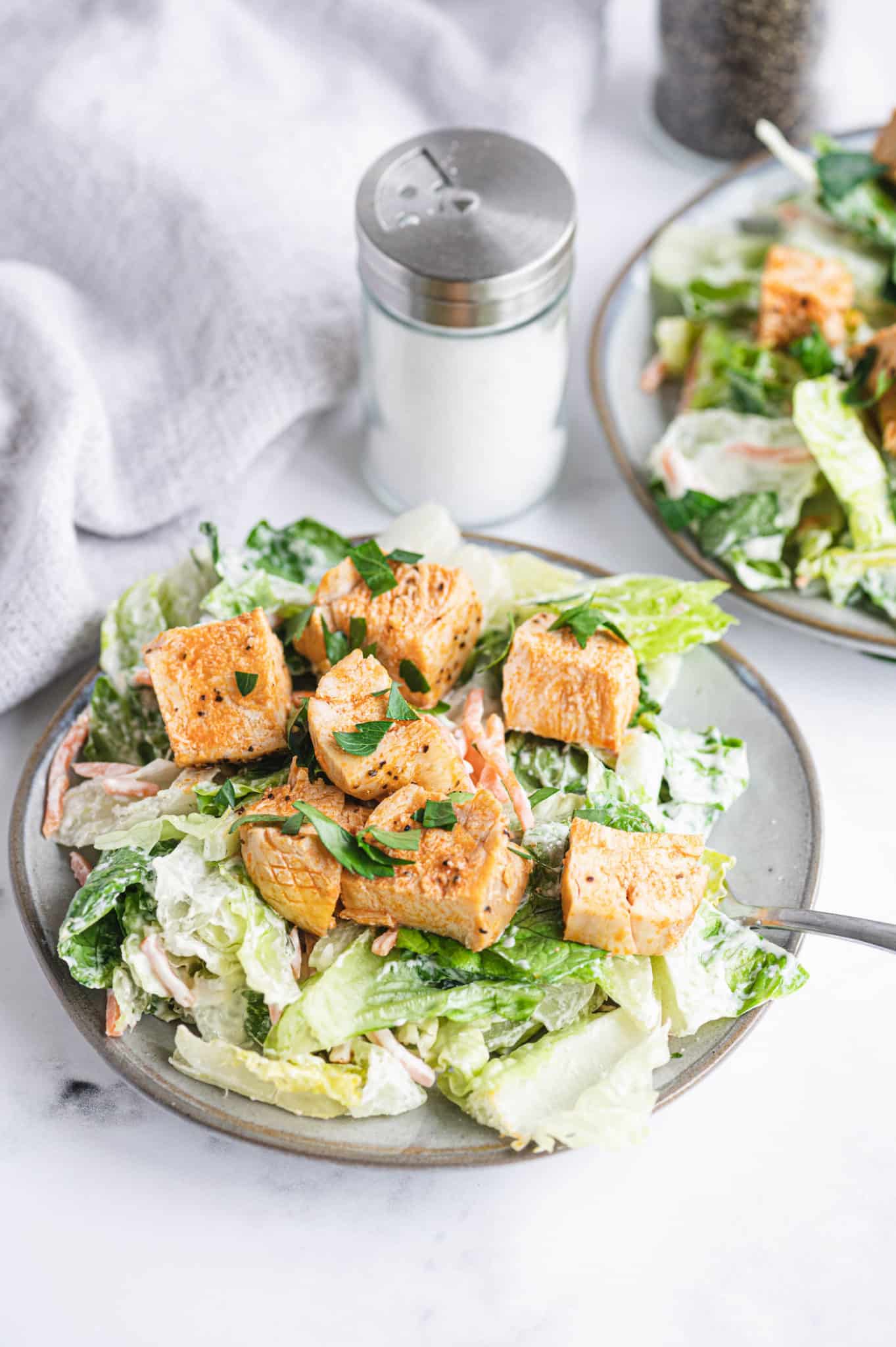 A plate of romaine salad with buffalo chicken