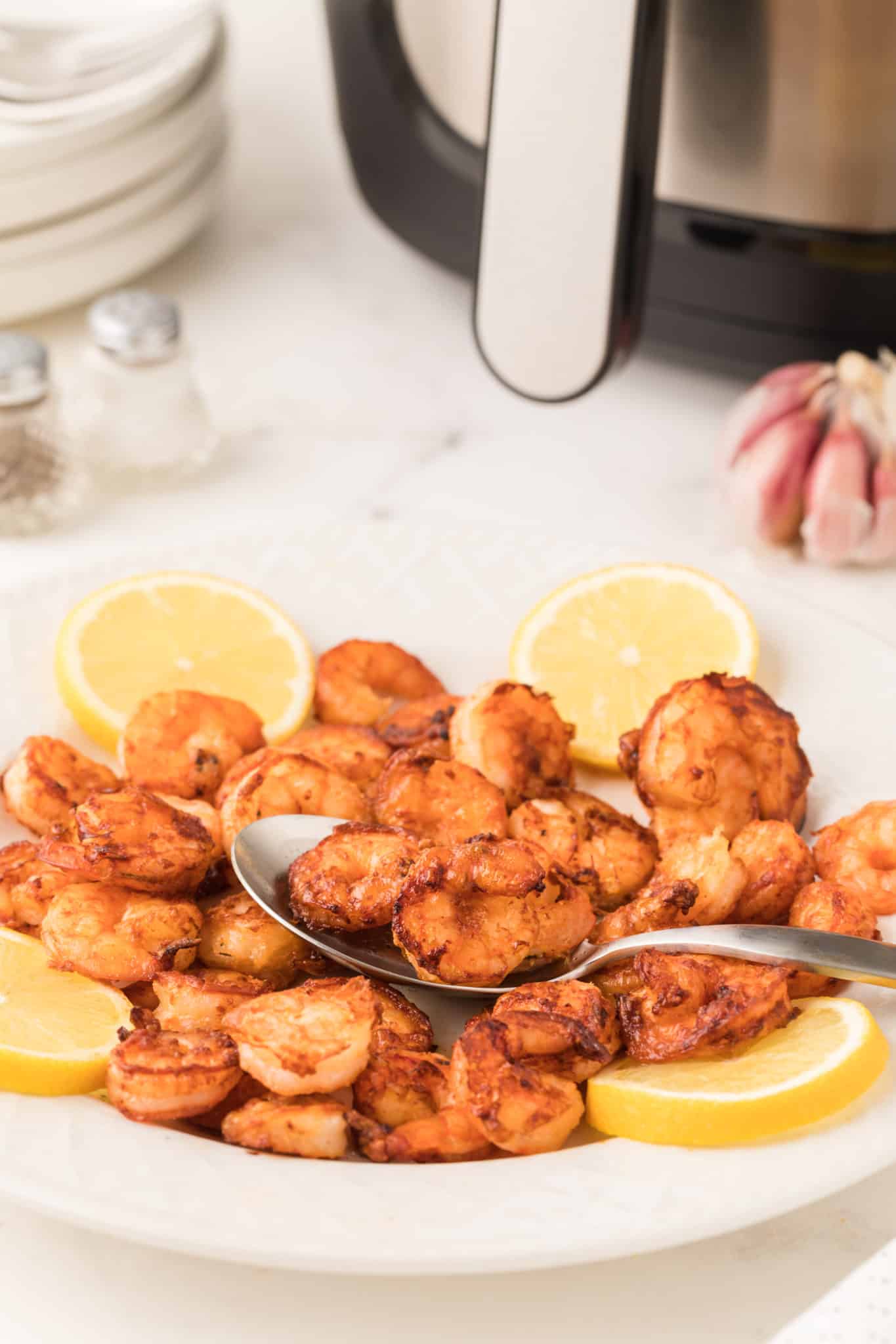 A bowl of cooked air fryer shrimp with lemon.