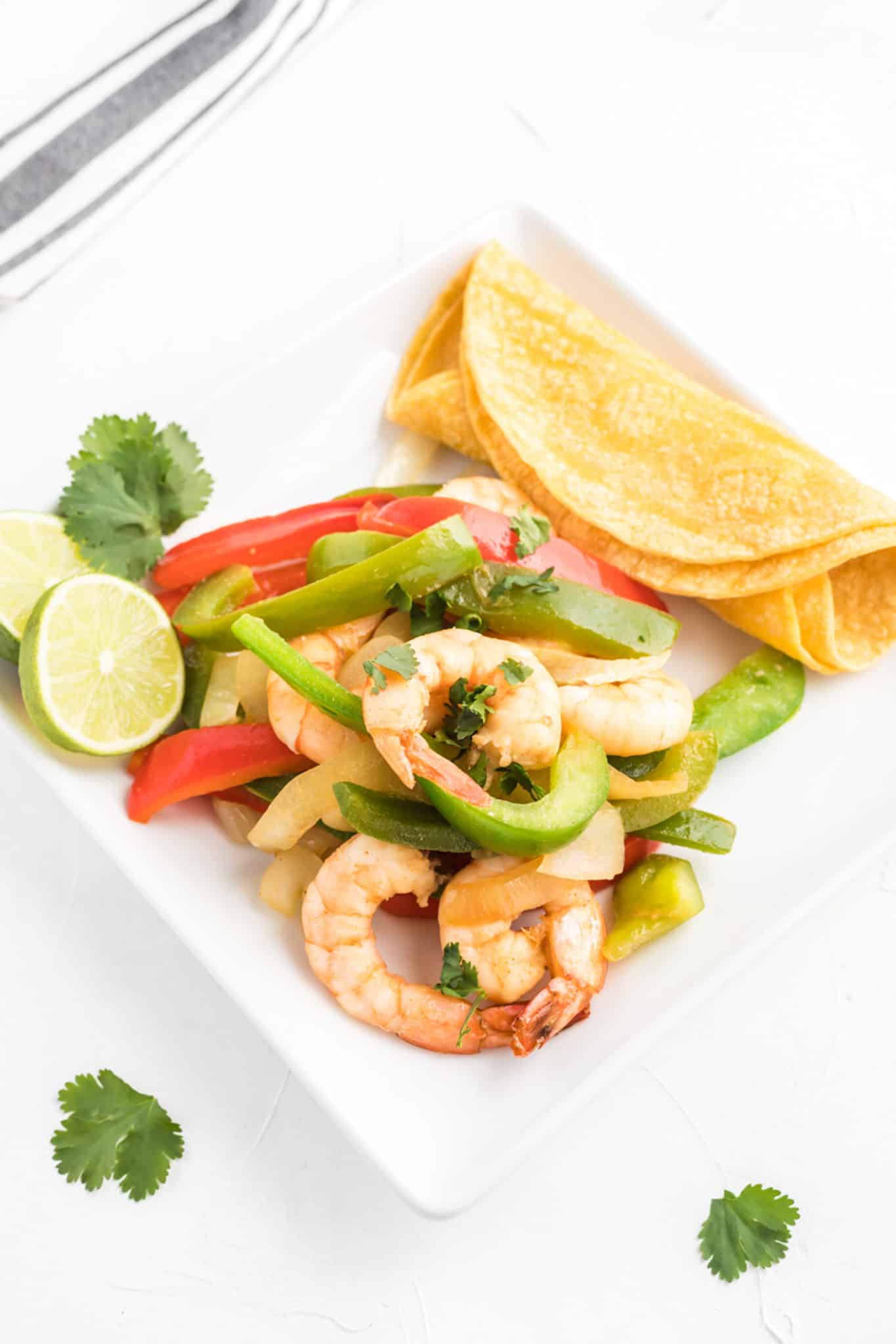 Sautéed shrimp and bell peppers with tortillas.