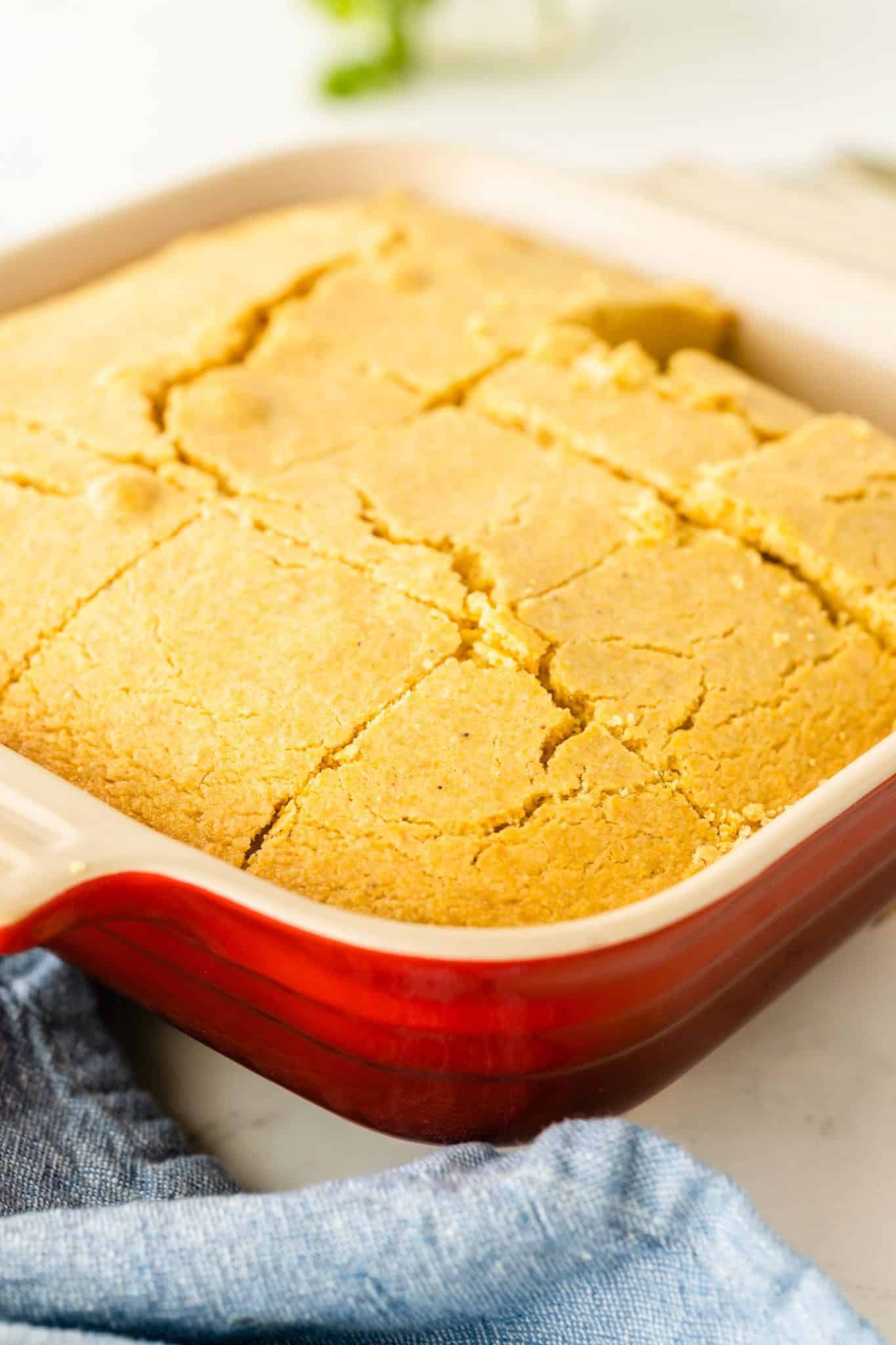 A close up of a pan of cornbread with a slice missing