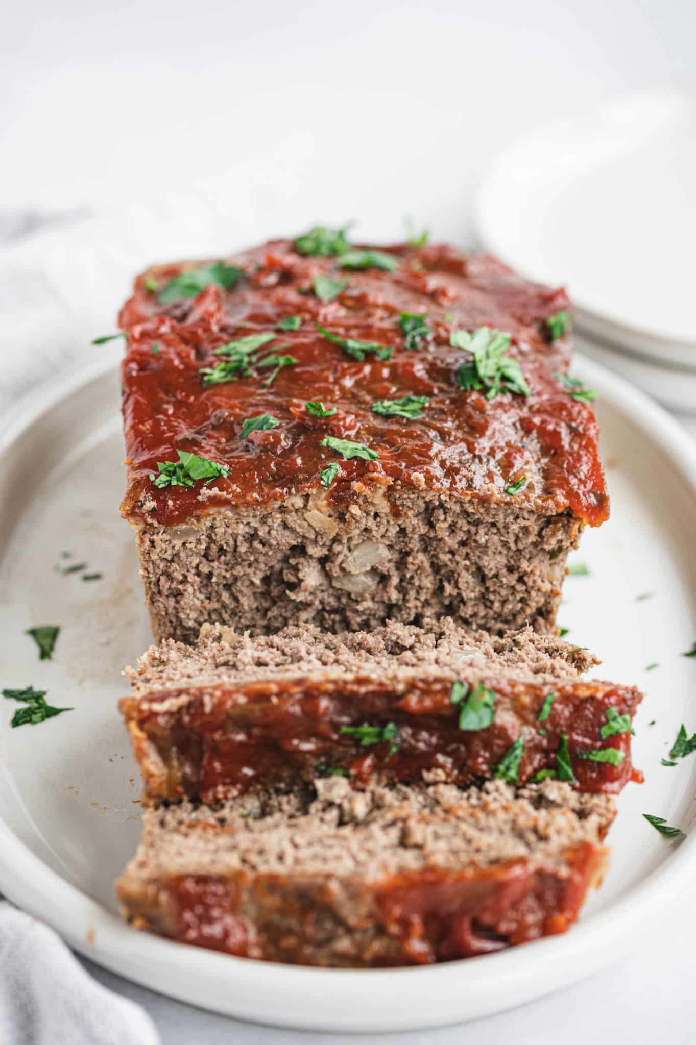 sliced meatloaf made without breadcrumbs served on a plate.