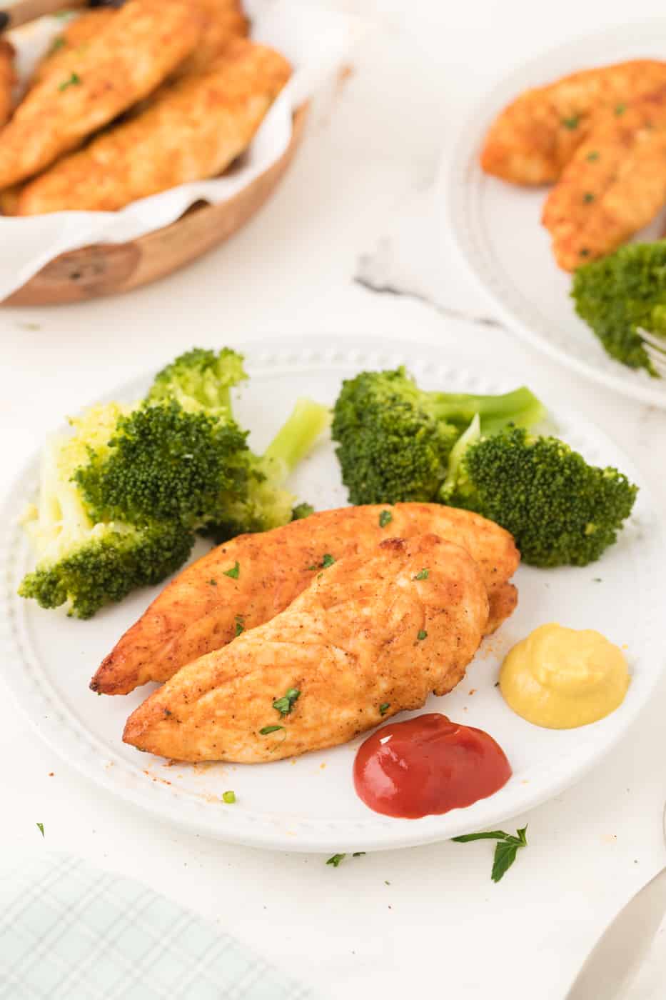 A plate of chicken tenders served with broccoli