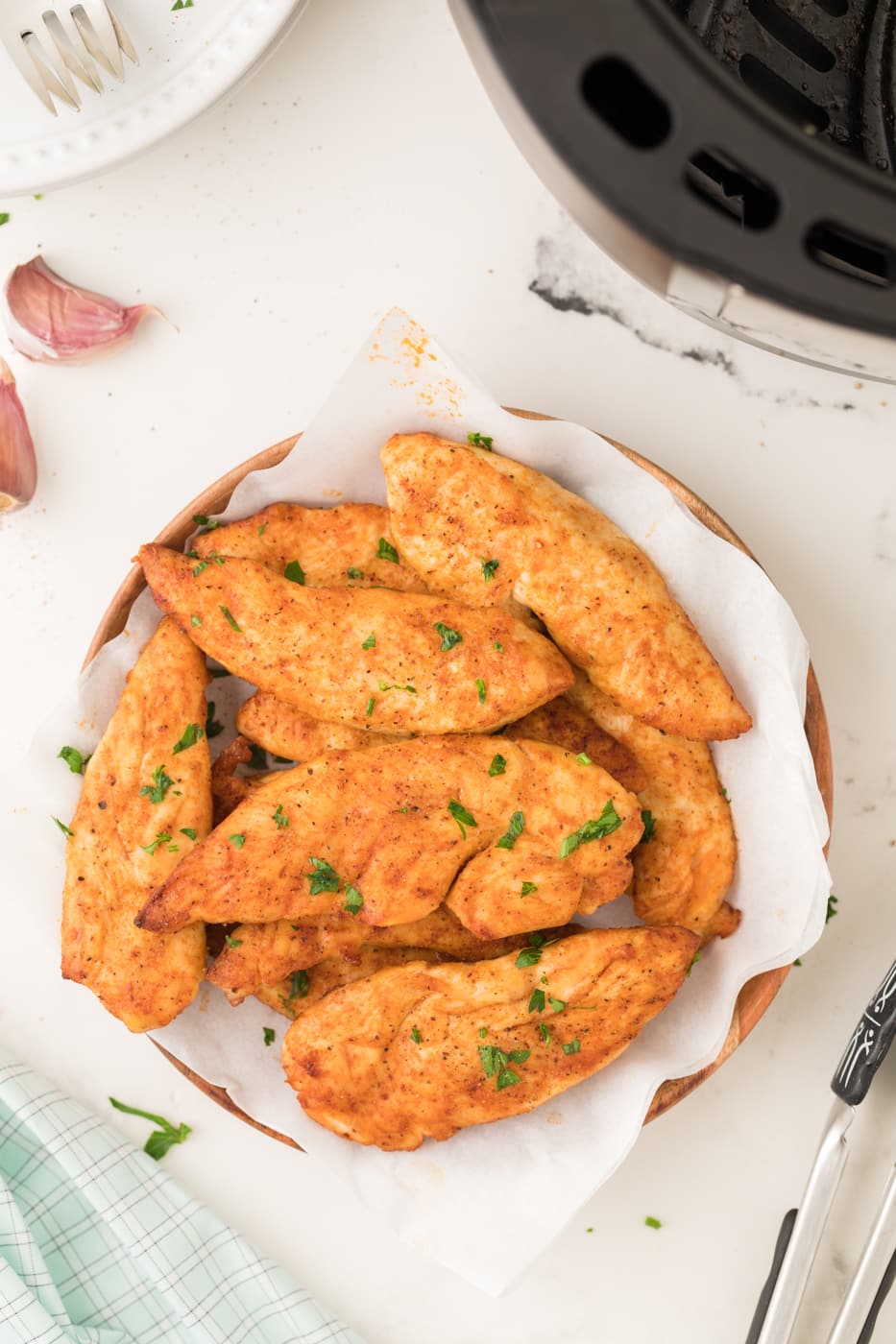 A plate of seasoned chicken tenders cooked in air fryer