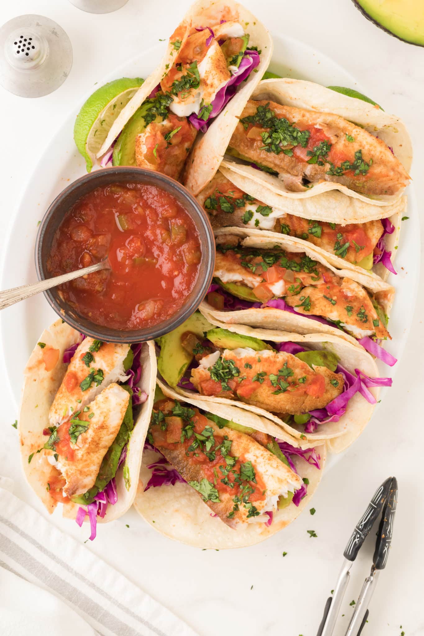 air fryer fish tacos served with avocado and salsa.