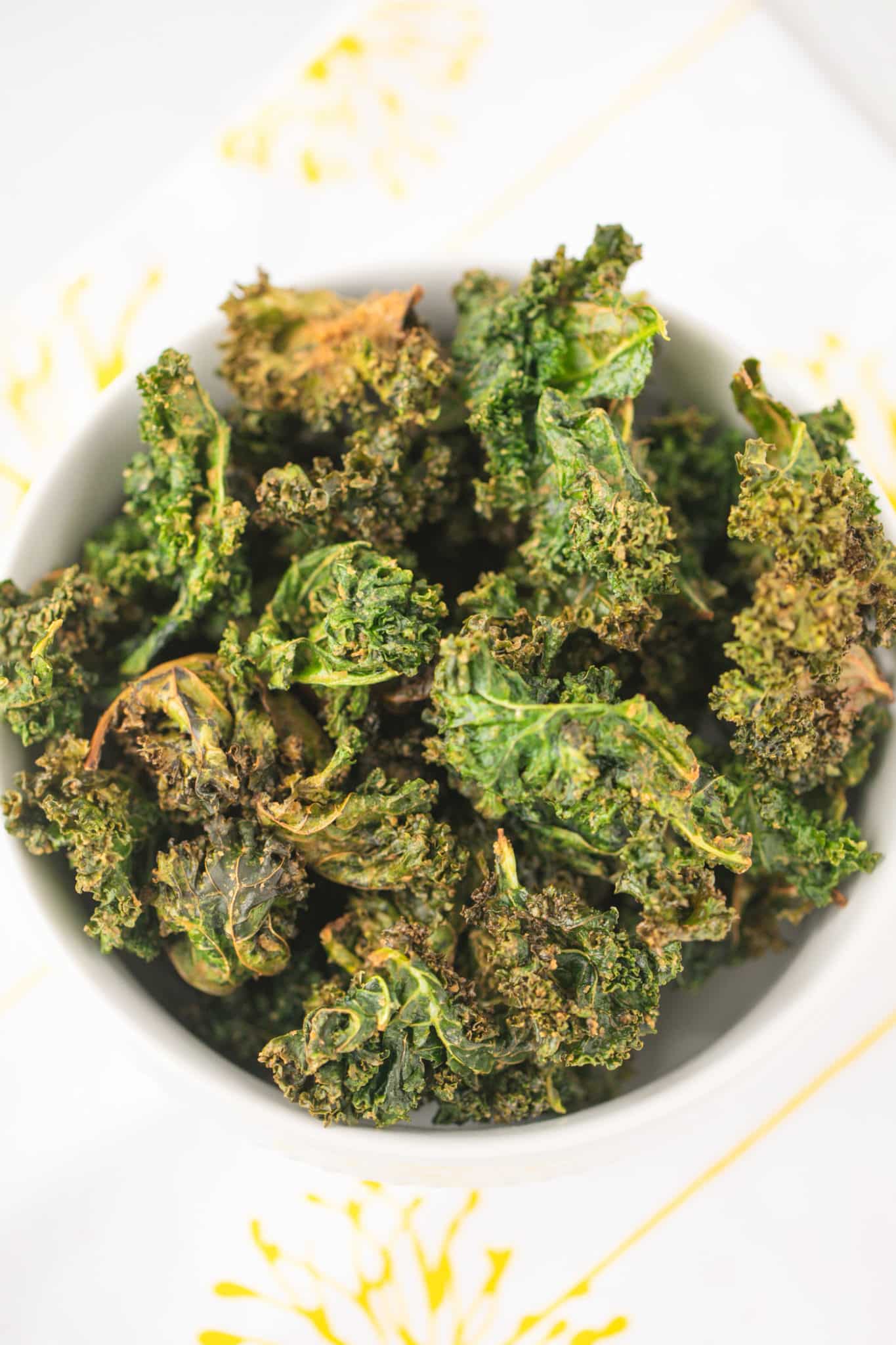 crispy air fried kale chips served in a white bowl