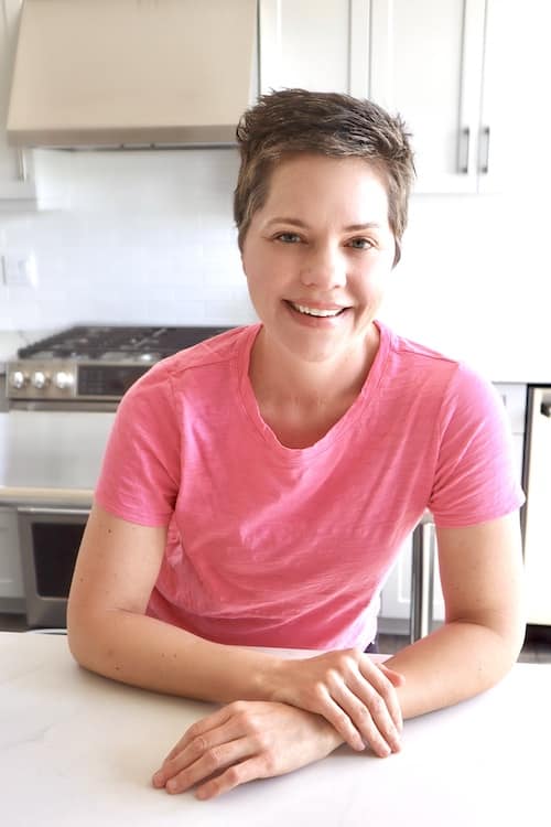 carre in pink shirt in white kitchen