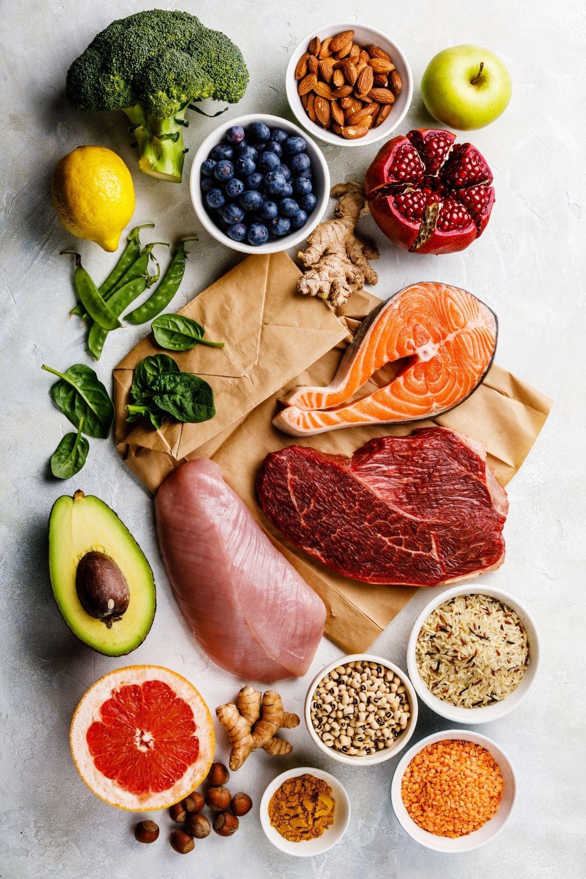 Fresh fruits, vegetables, and raw meat on a counter.