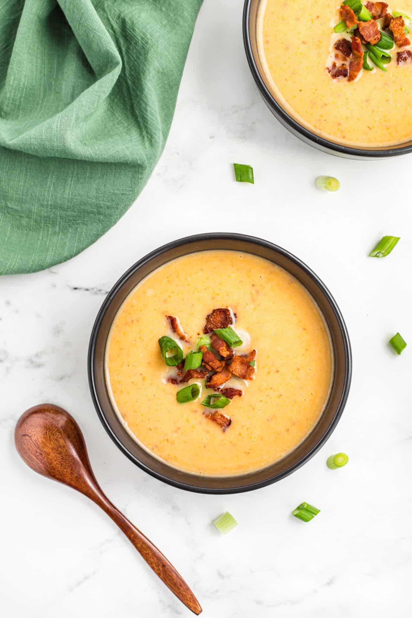 two bowls of potato soup with bacon and scallions