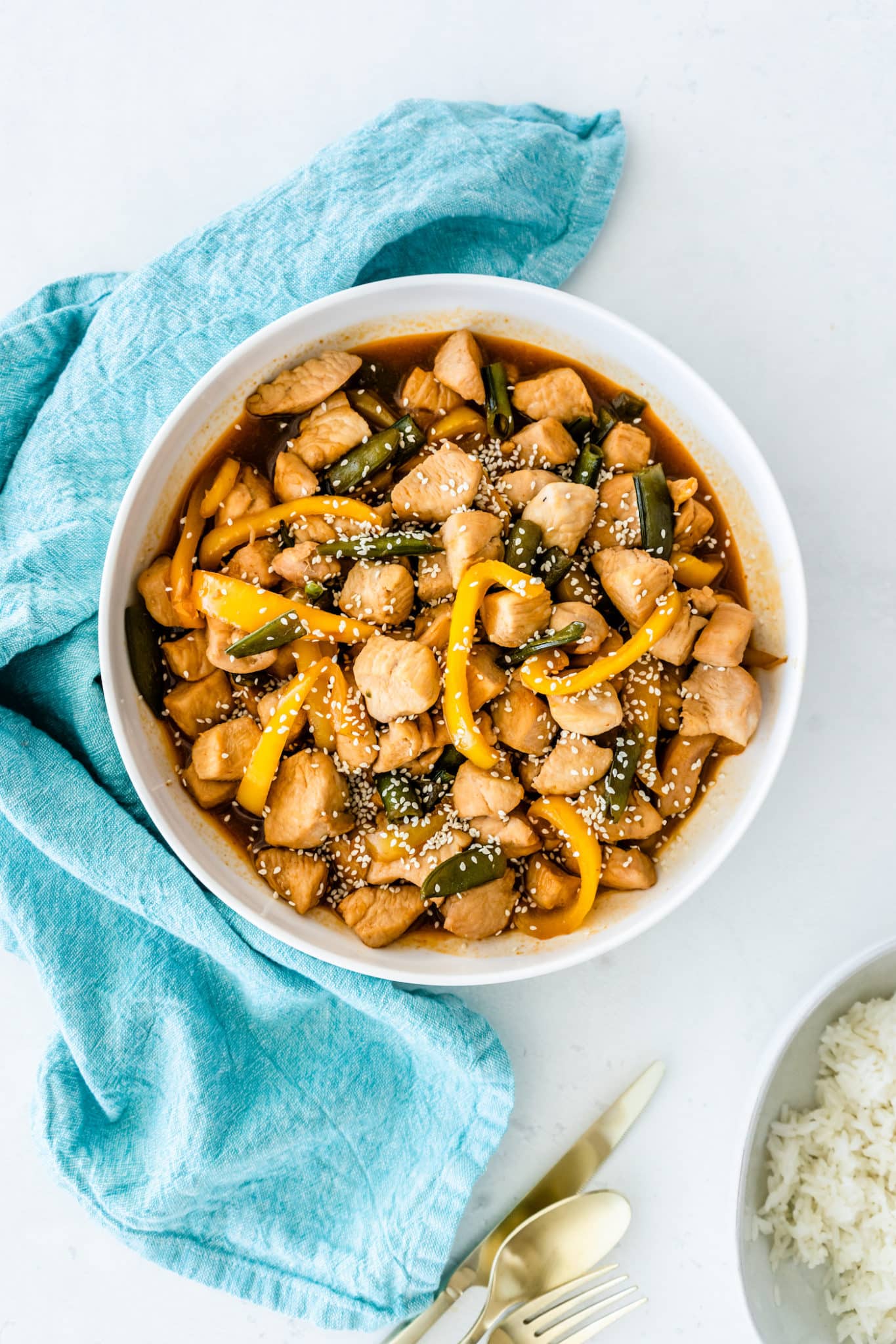 A bowl of panda express honey sesame chicken with bell peppers.