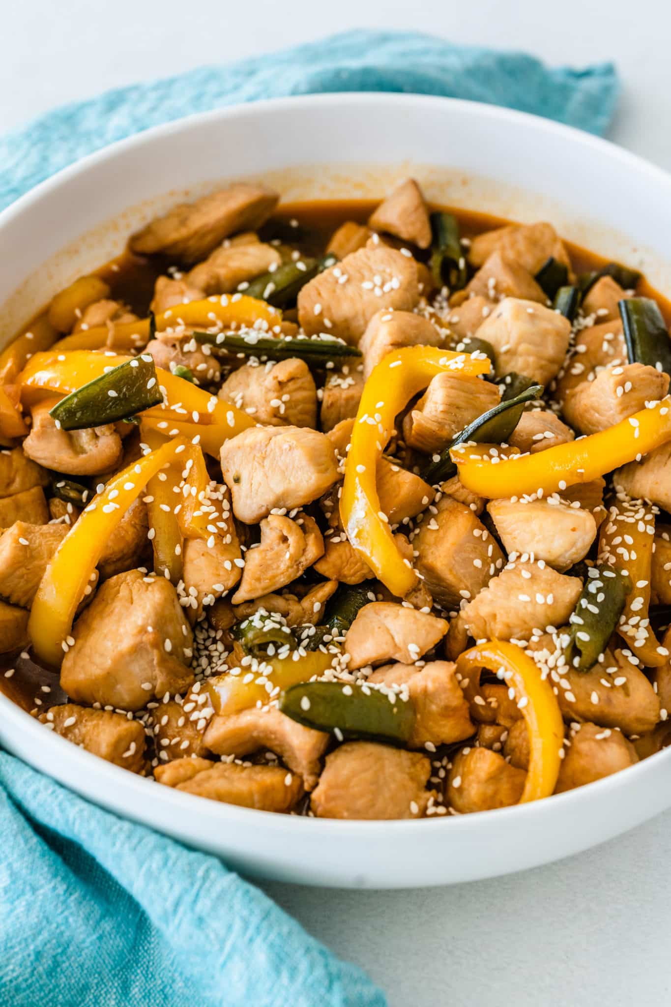 A bowl of sesame chicken with bell peppers