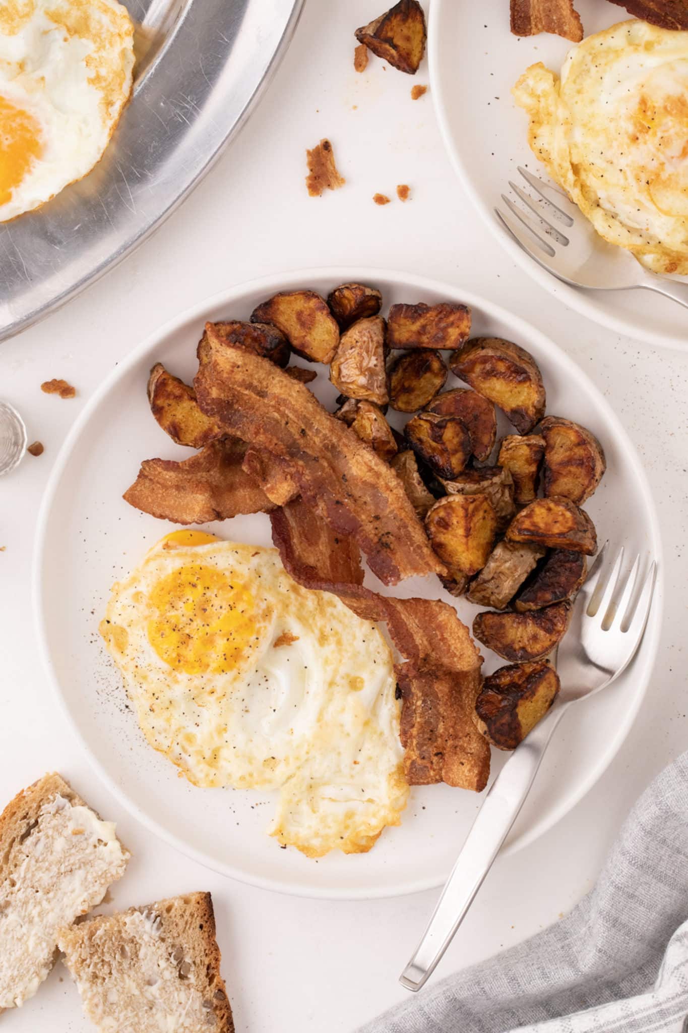 breakfast plate served with eggs, bacon and potatoes.