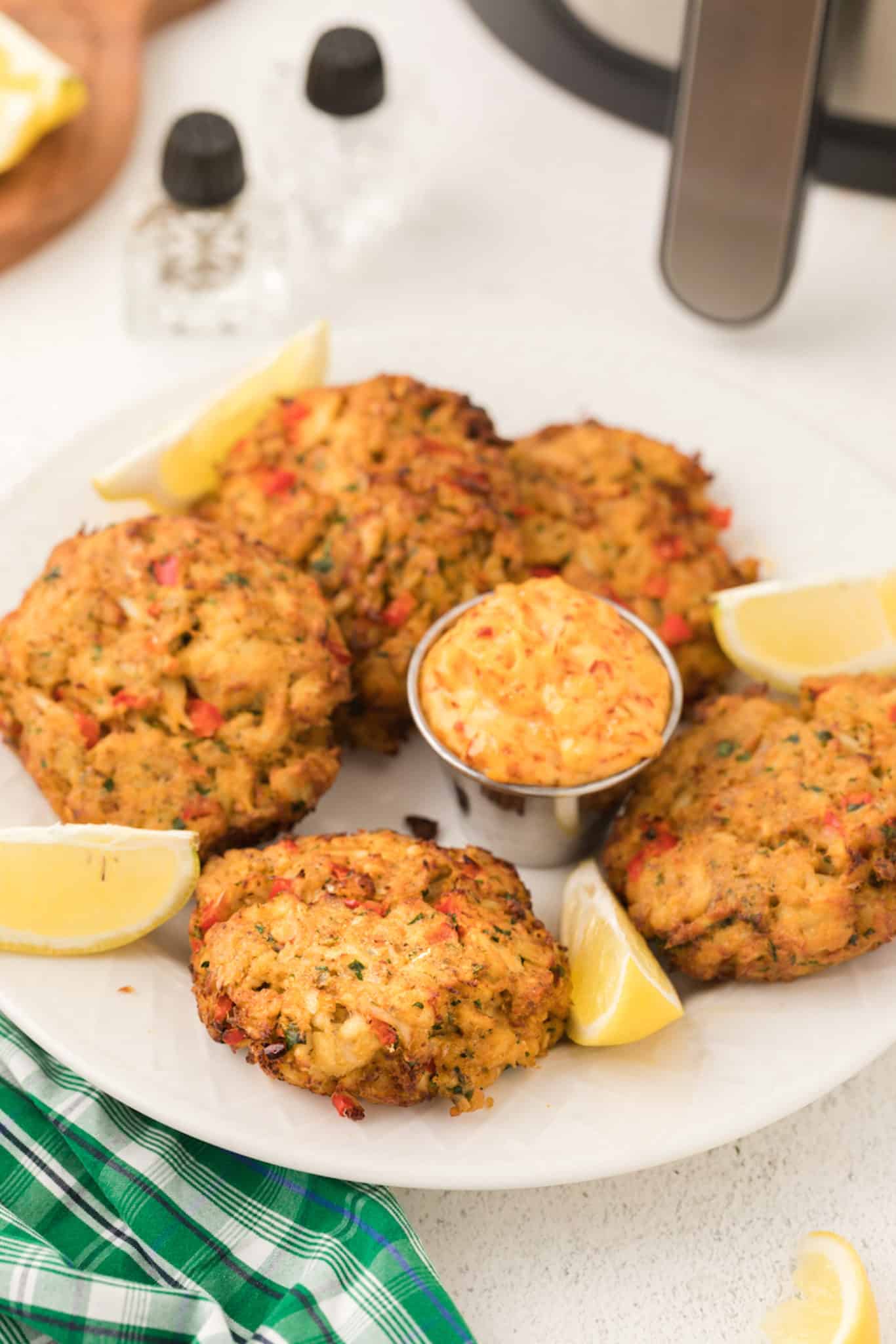 serving plate with crab cakes, lemon slices, and dipping sauce