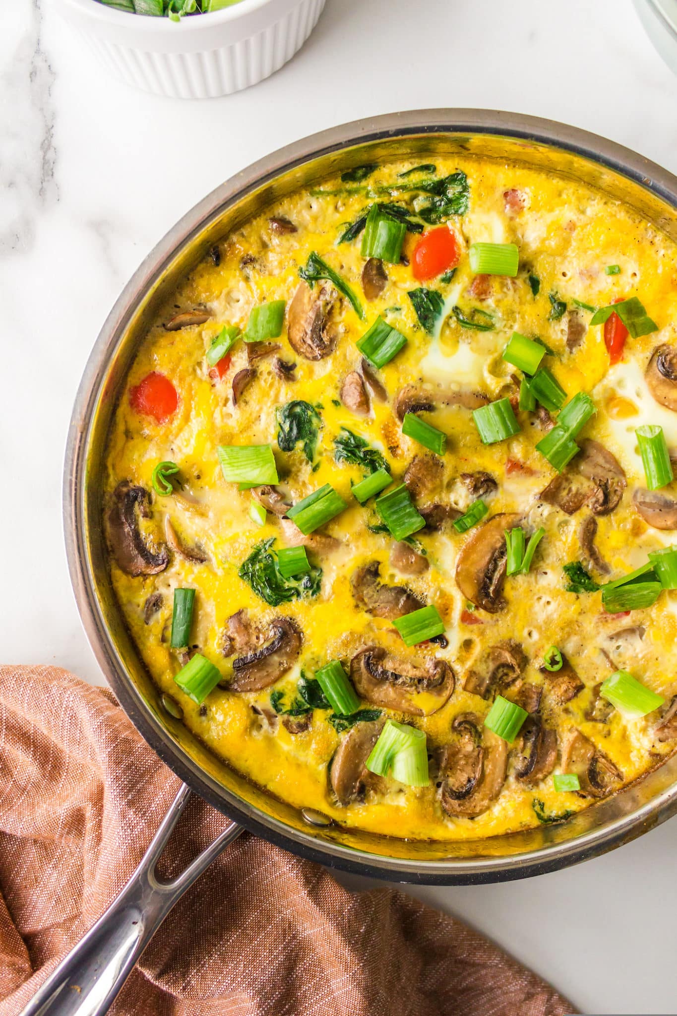 A vegetable gluten-free frittata without dairy baked in a pan.