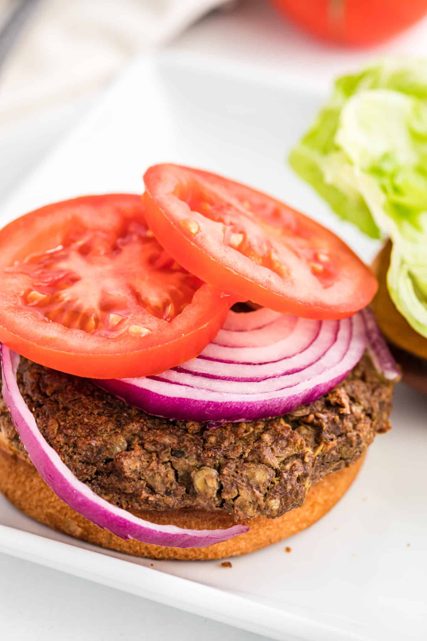 A lentil burger with onion and tomato