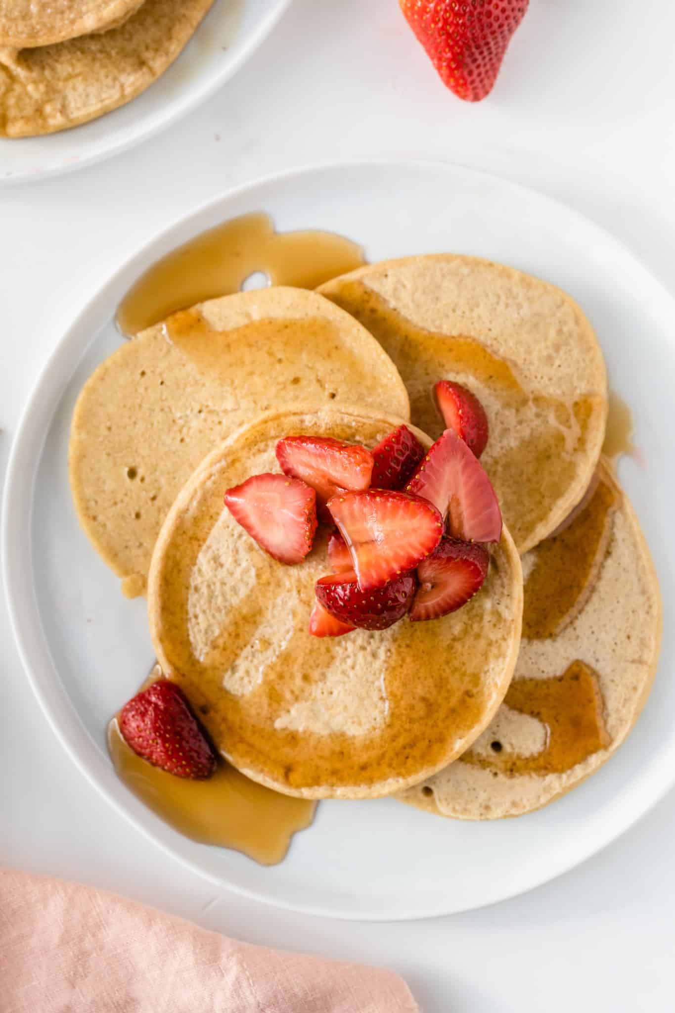 Gluten free pancakes with strawberries and syrup