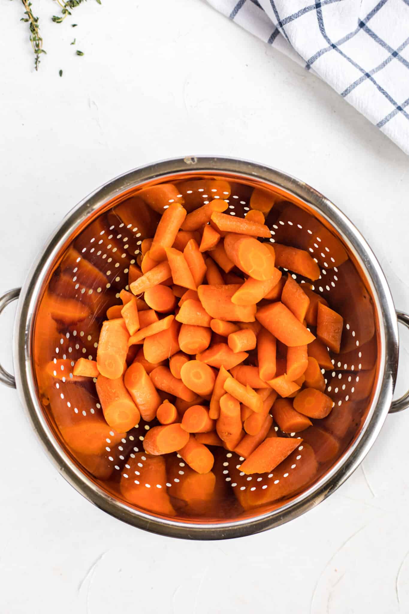 draining cooked carrots.