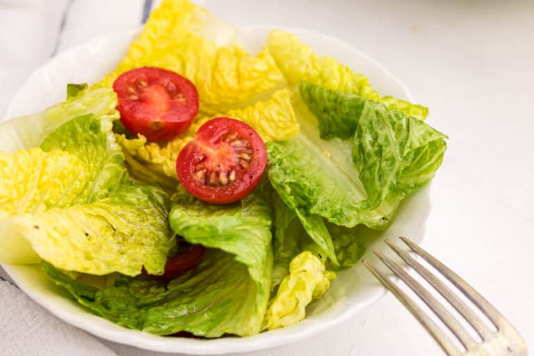 romaine salad on a white plate with a fork