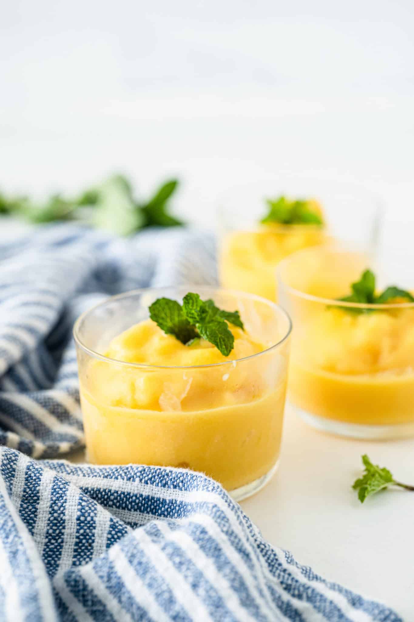 glasses of mango sorbet with fresh mint leaves on top