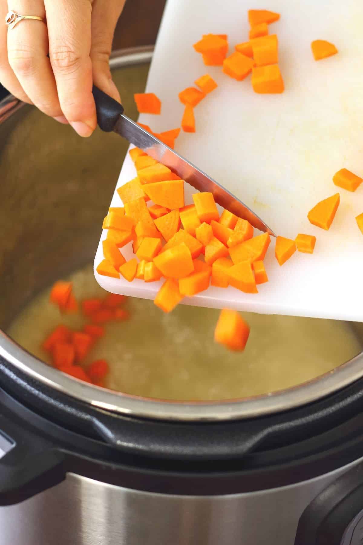 woman putting chopped carrots in an instant pot