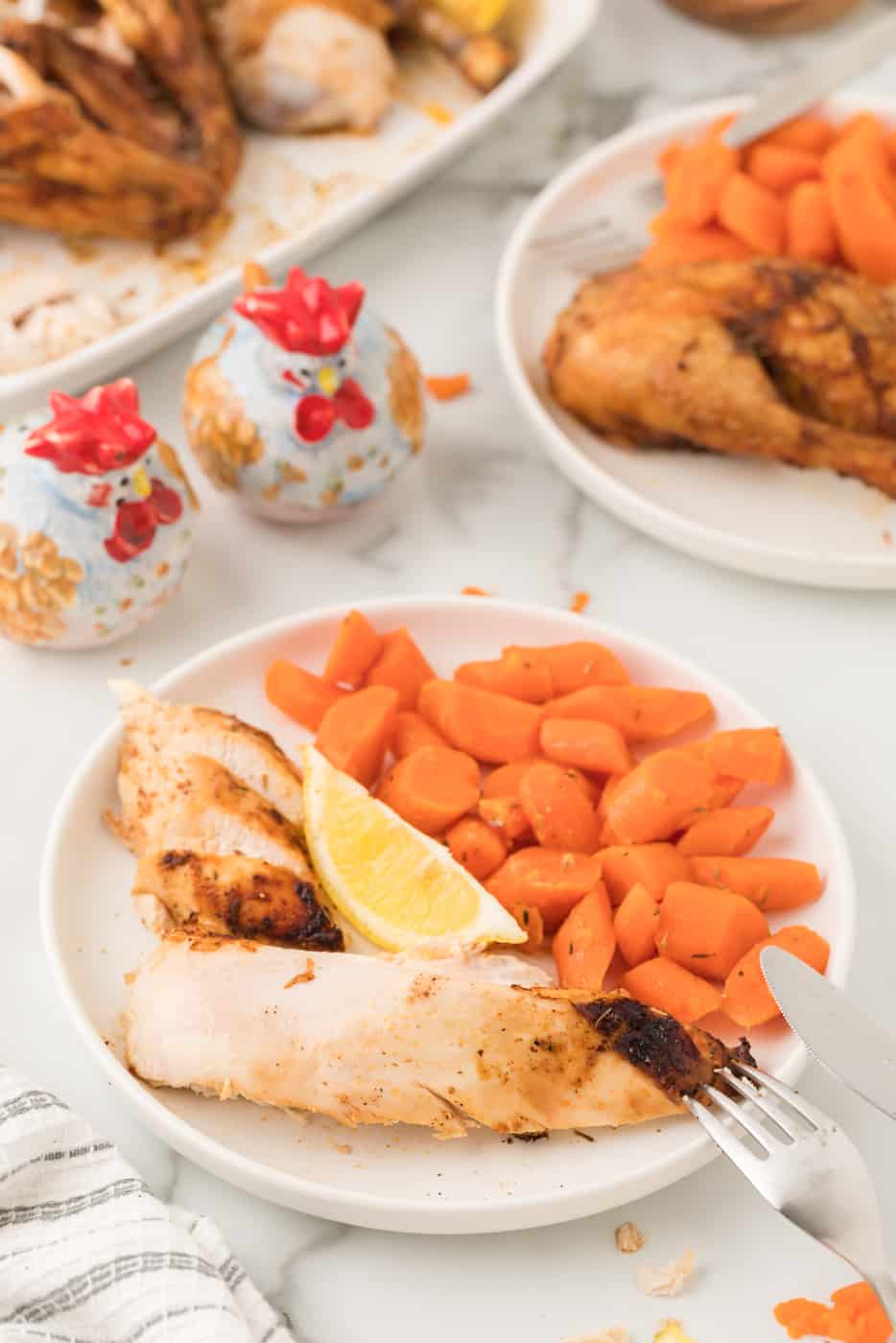 air fried chicken served with with veggies and lemon on plate.