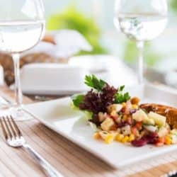 plate on a table with a glass of white wine