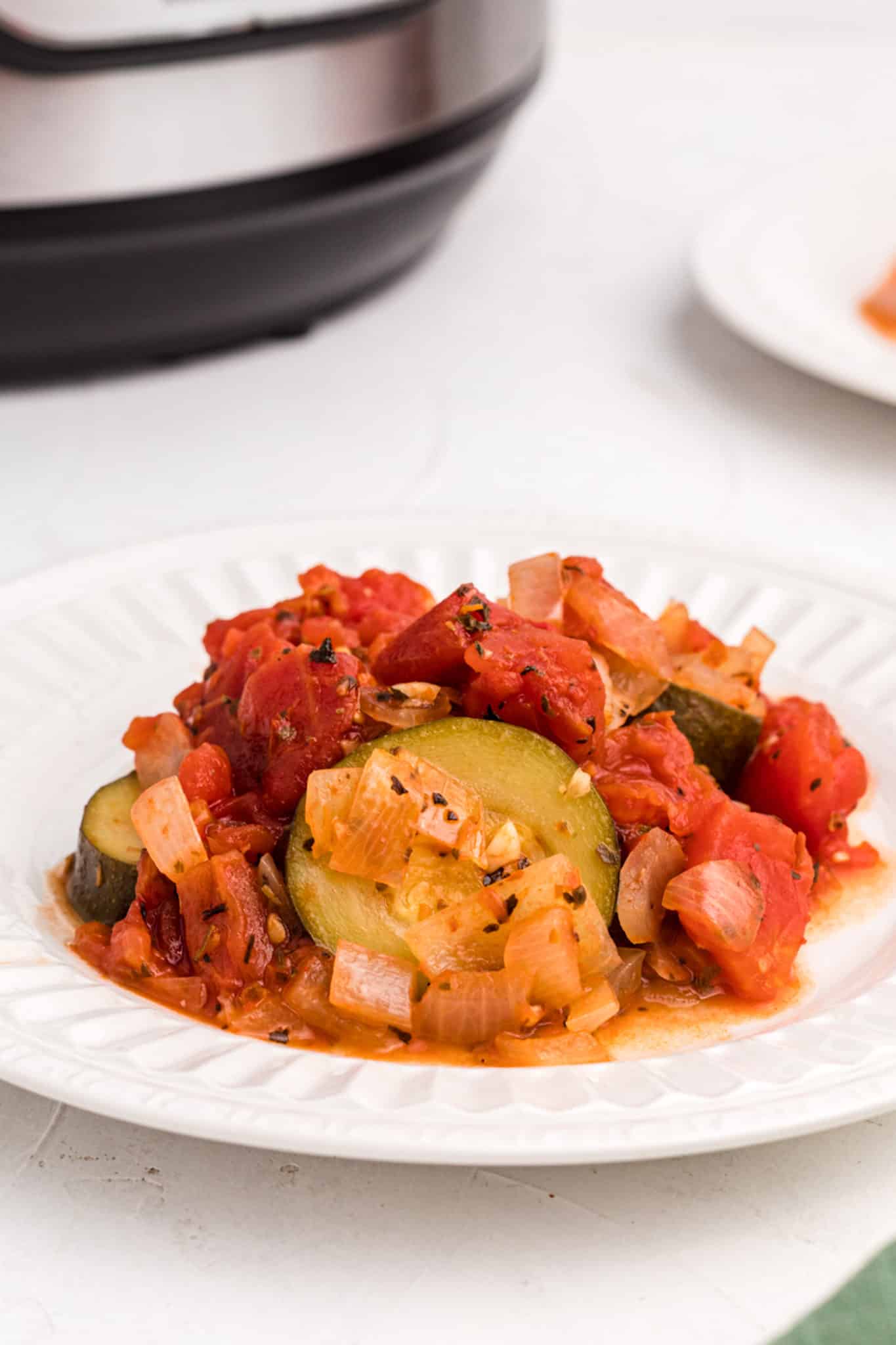 cooked instant pot zucchini and tomatoes on a plate
