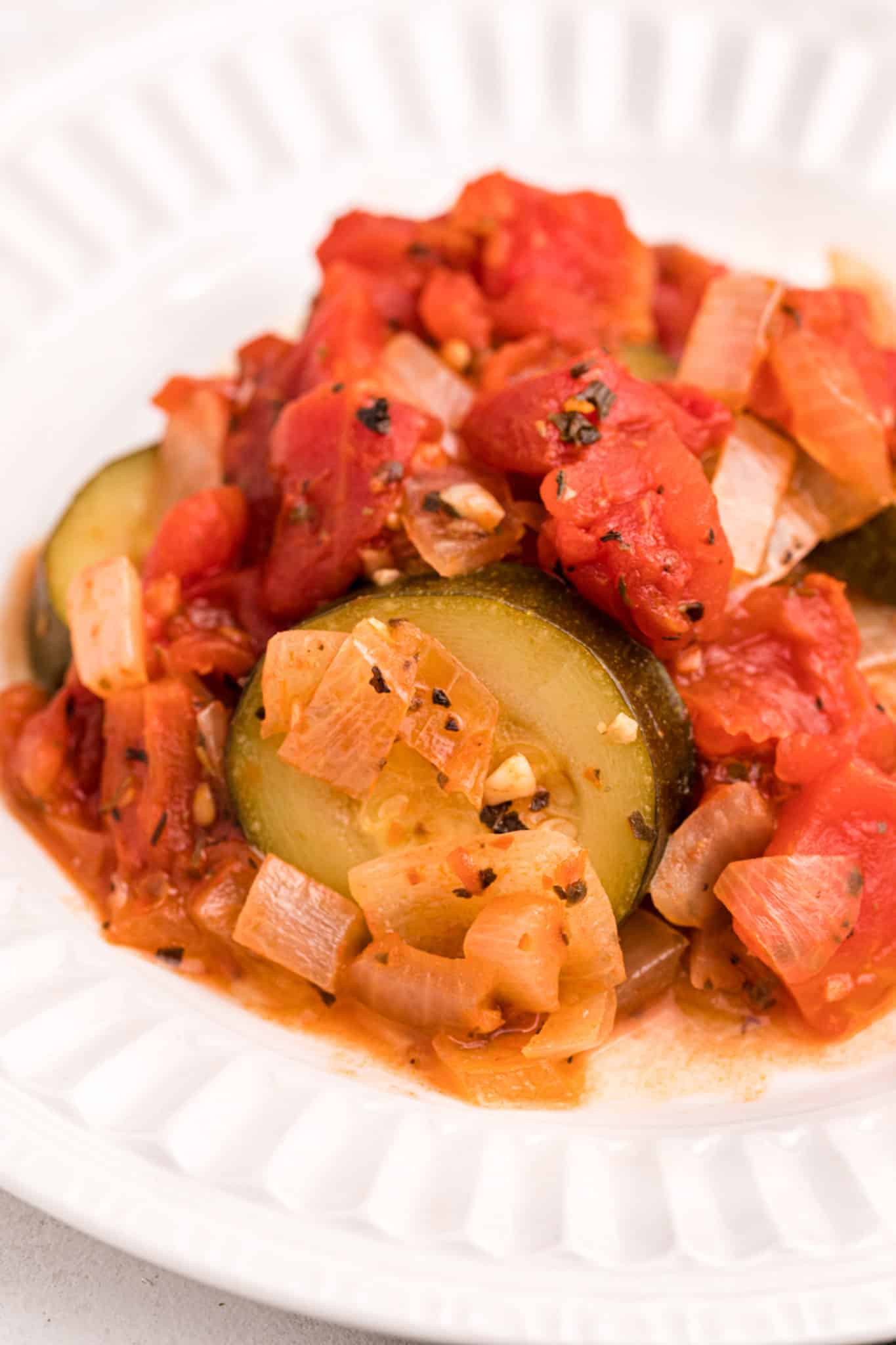 up close photo of cooked zucchini with onions, garlic and tomatoes