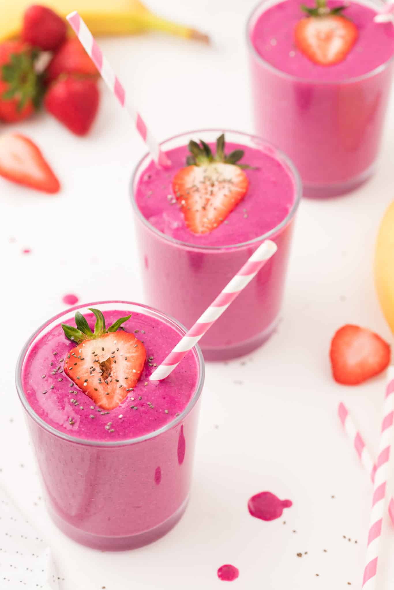 dragon fruit smoothies with pink striped straws.