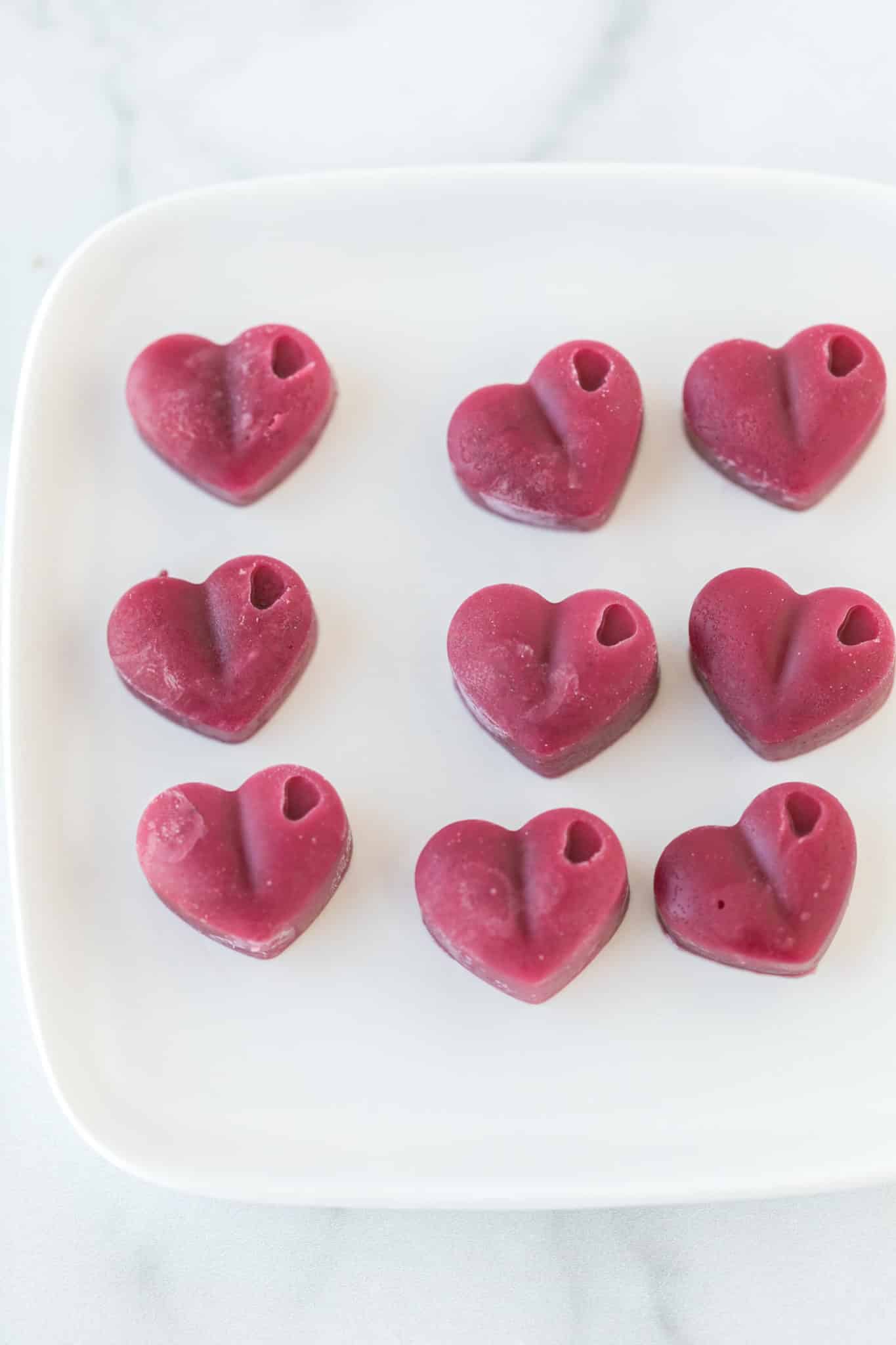 plate with pink heart-shaped vegan gummies.