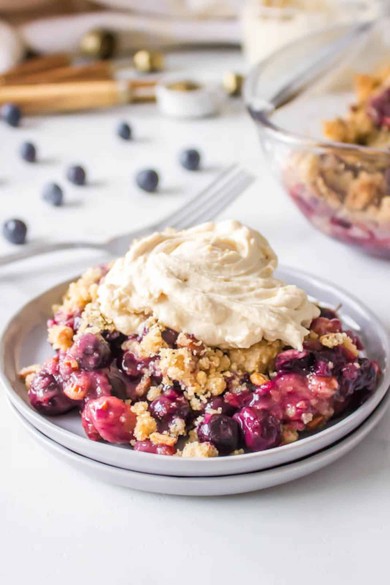 blueberry crisp served with a coconut whip topping.