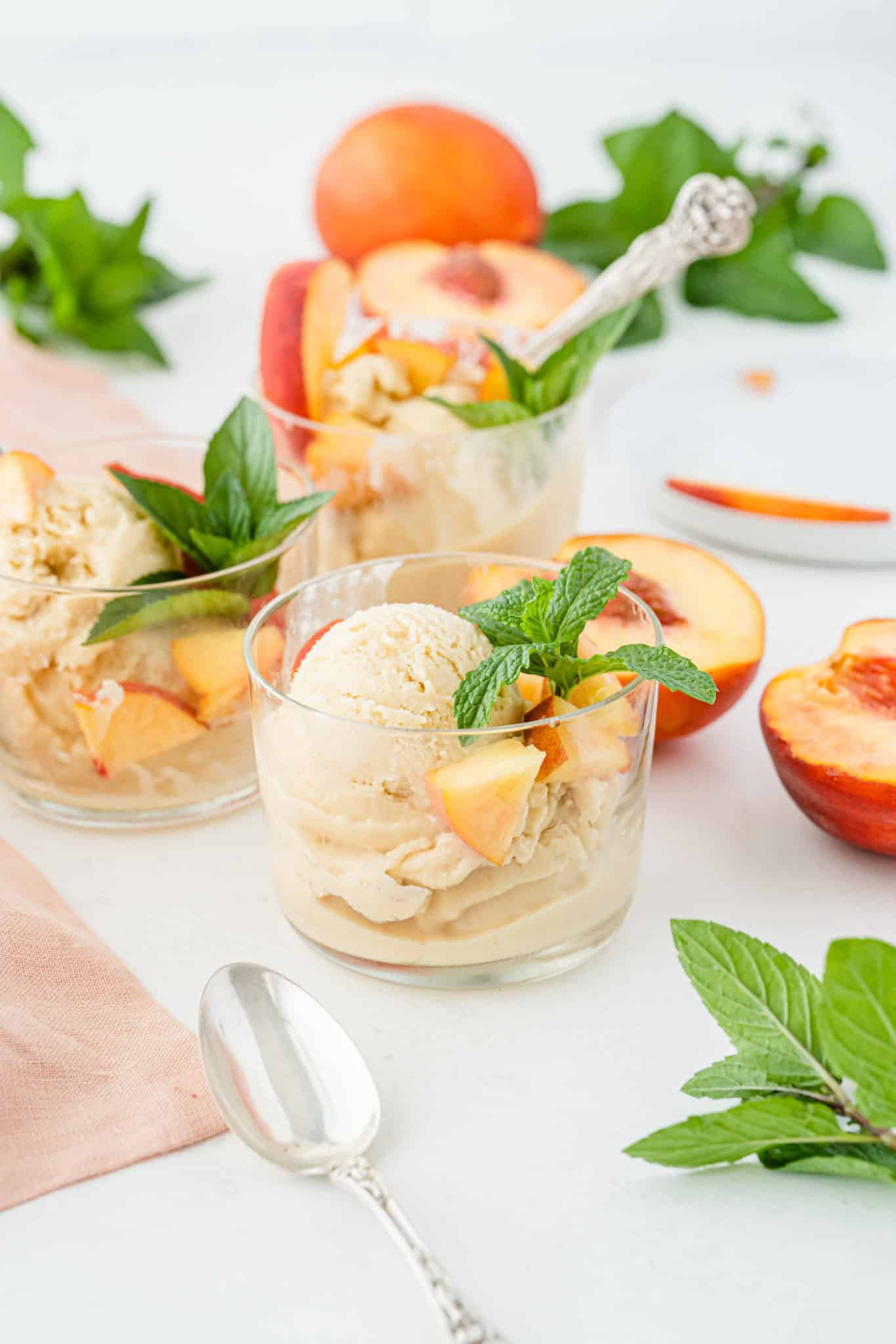 peach ice cream served in bowls with spoons