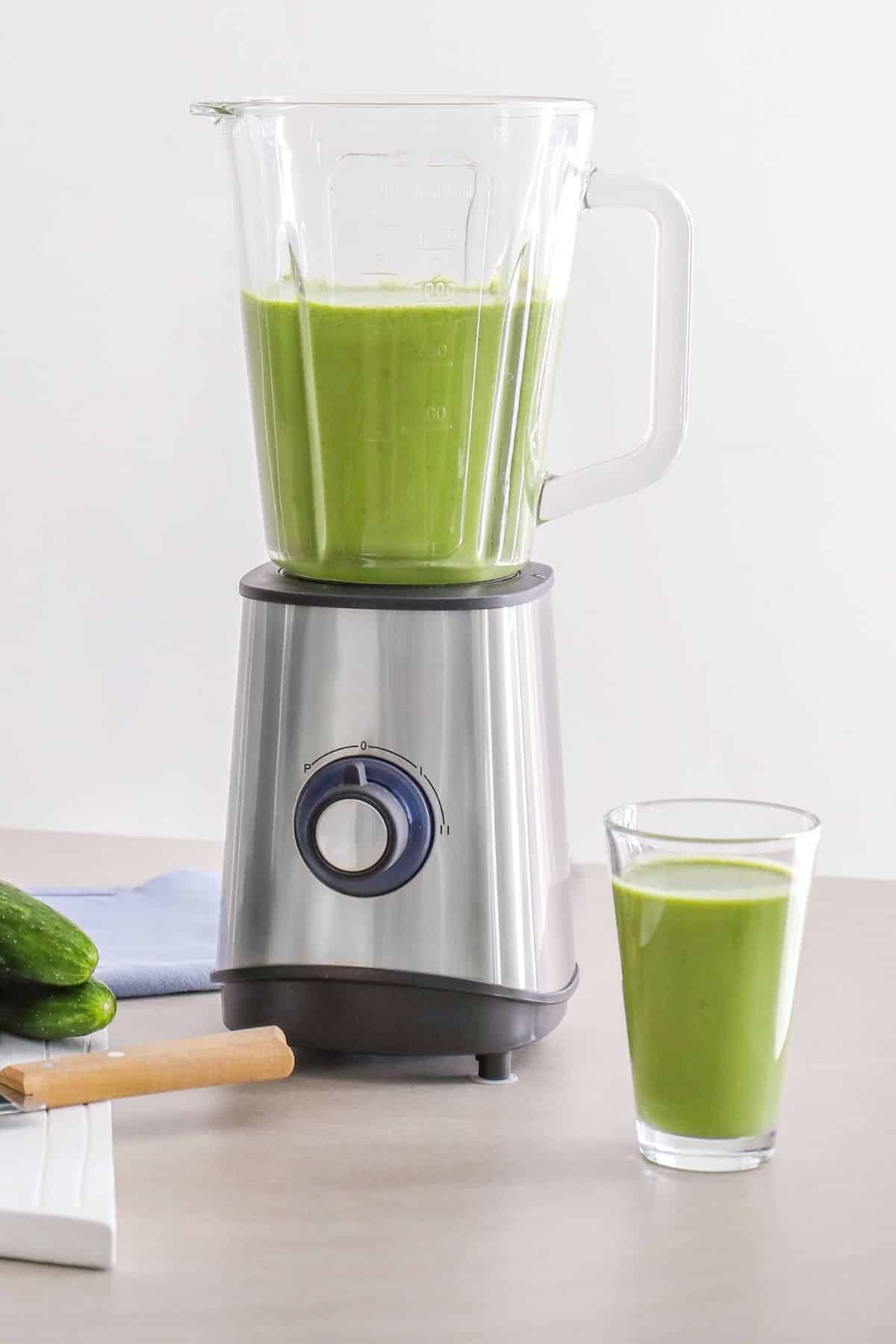 blender filled with green smoothie.