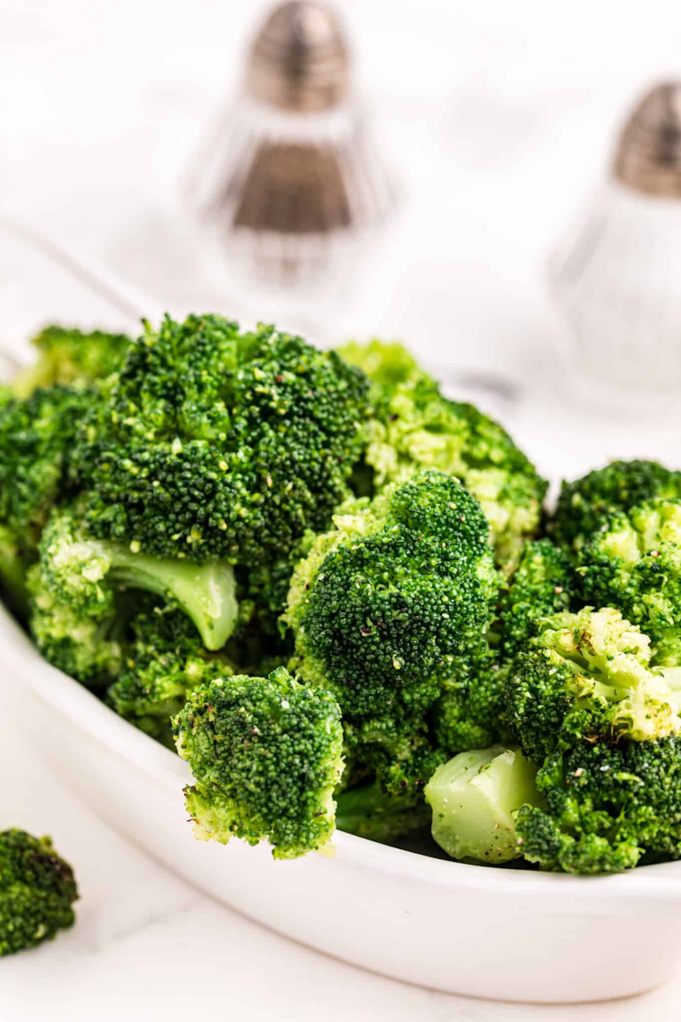 cooked broccoli ready to serve in white dish.