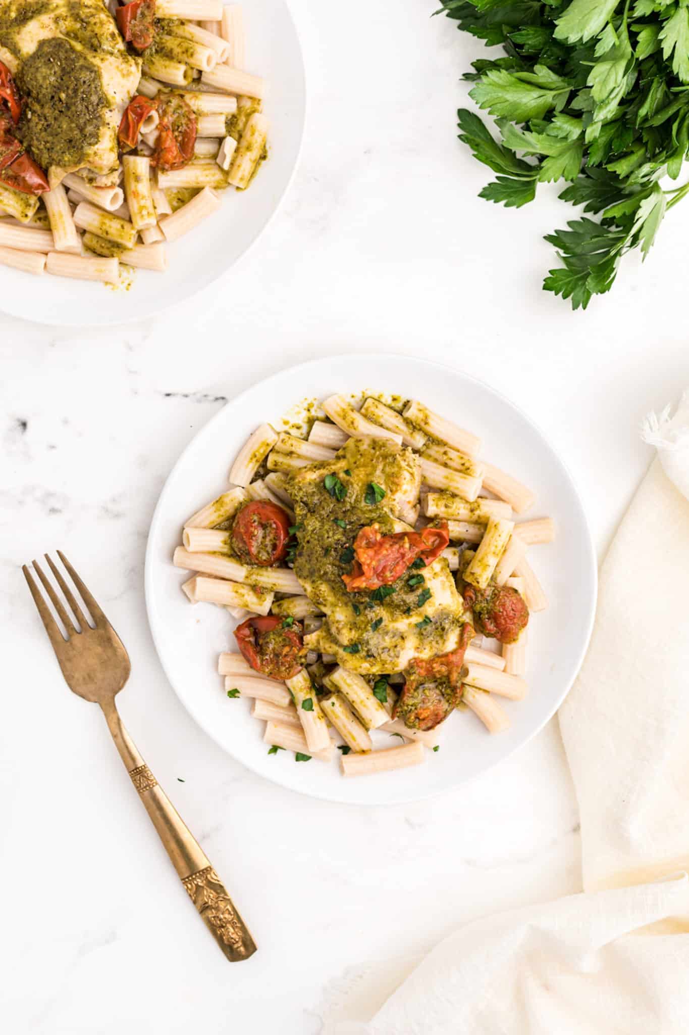 two plates of pesto chicken served on top of gluten-free pasta