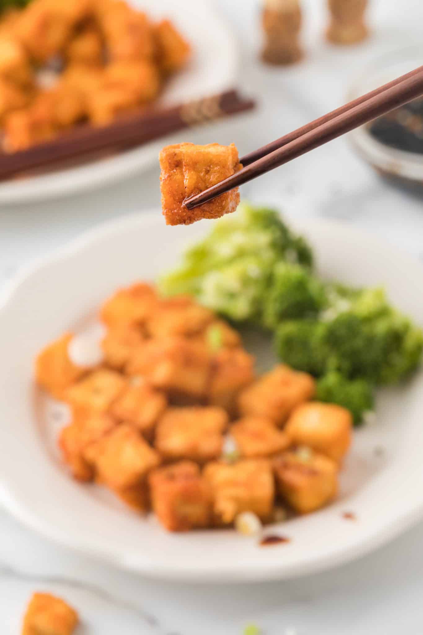 piece of tofu served with chopsticks